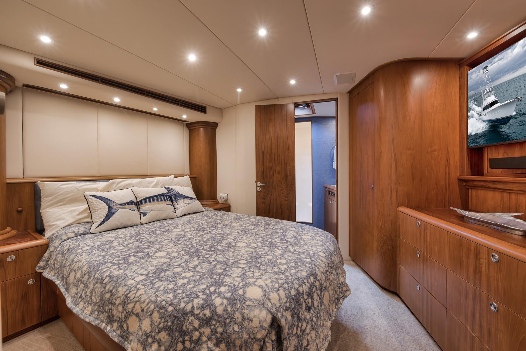 Luxurious 1997 Merritt 58 yacht bedroom with elegant wood finishes and cozy bedding.