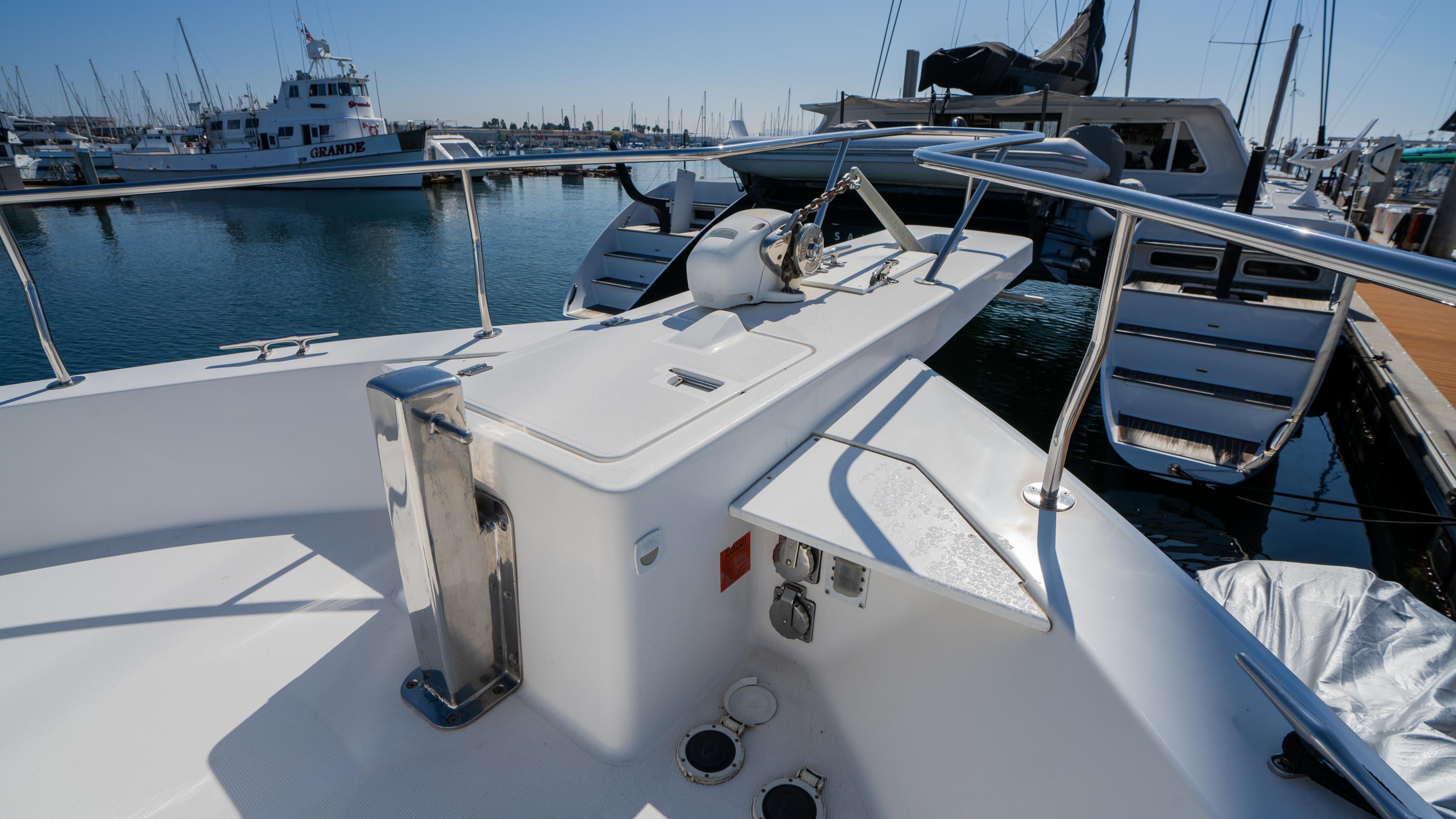 2005 Mainship 43 Trawler Aft Cabin, docked in a marina, showcasing deck and railing.