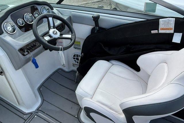 Interior of 2021 Chaparral 21 SSi boat, featuring steering wheel and white captain's seat.