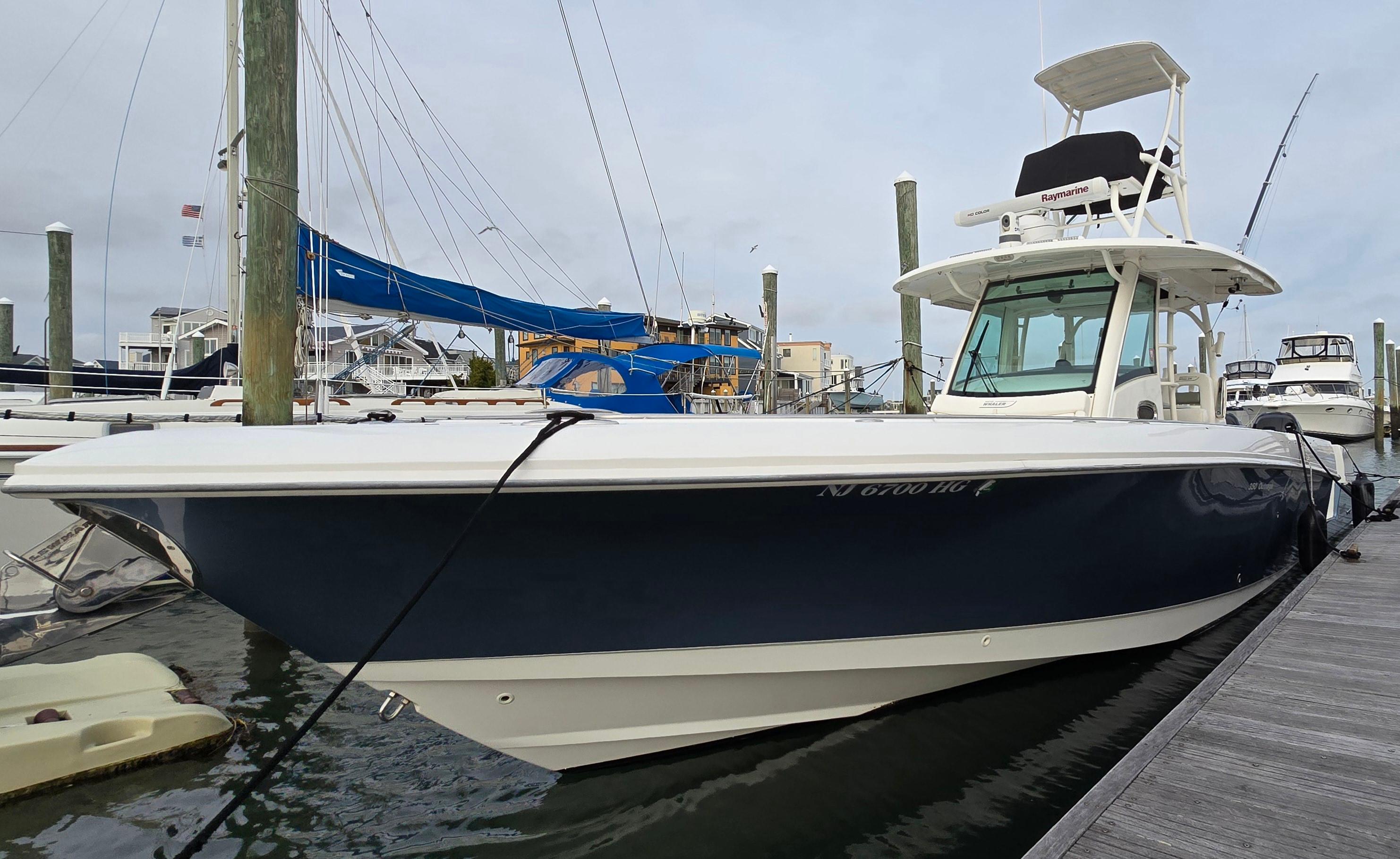 2015 Boston Whaler 350 Outrage docked at marina, side view.