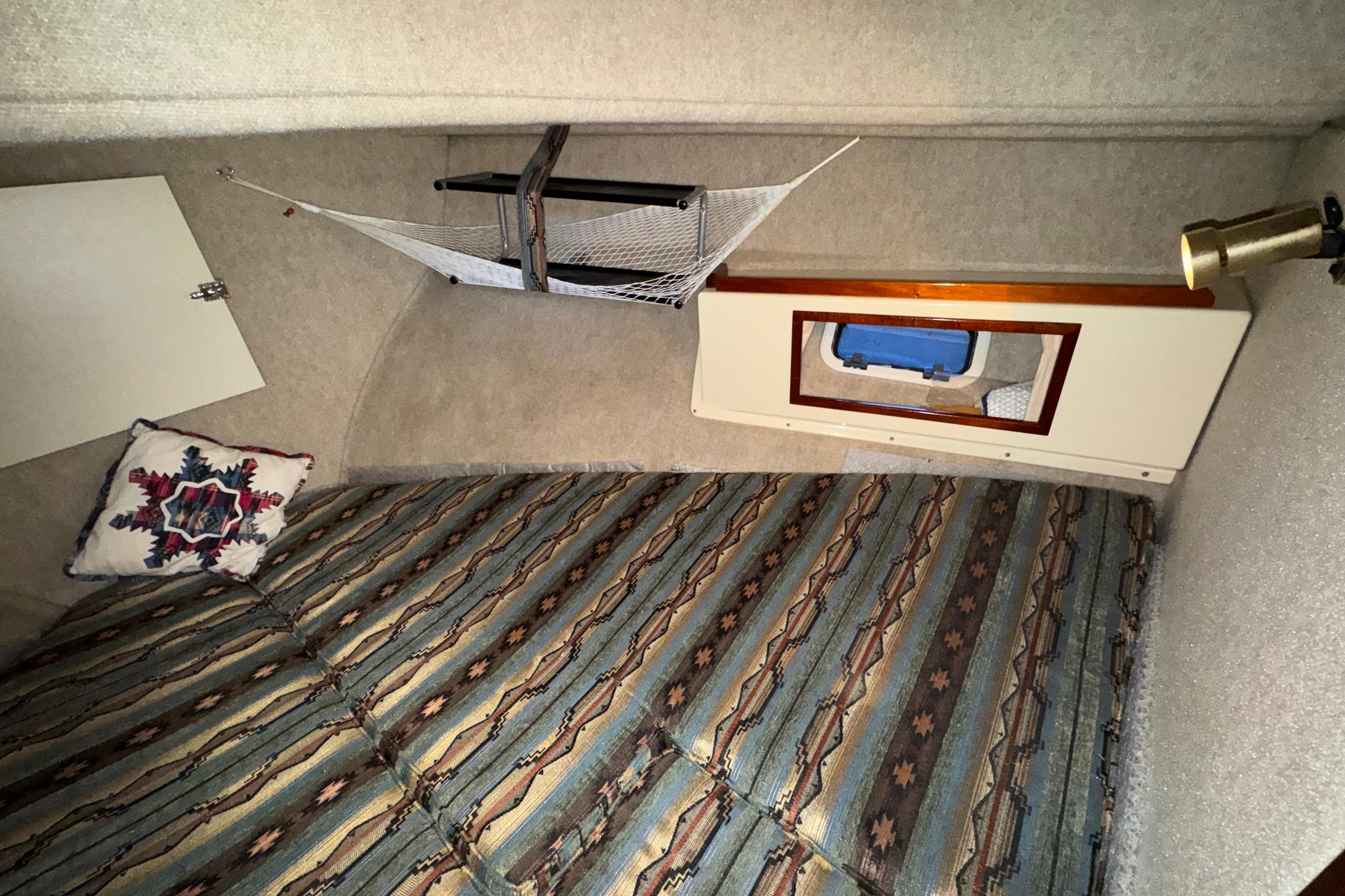 Interior cabin of 2004 Camano 31 Troll boat with patterned bedding and decorative pillow.