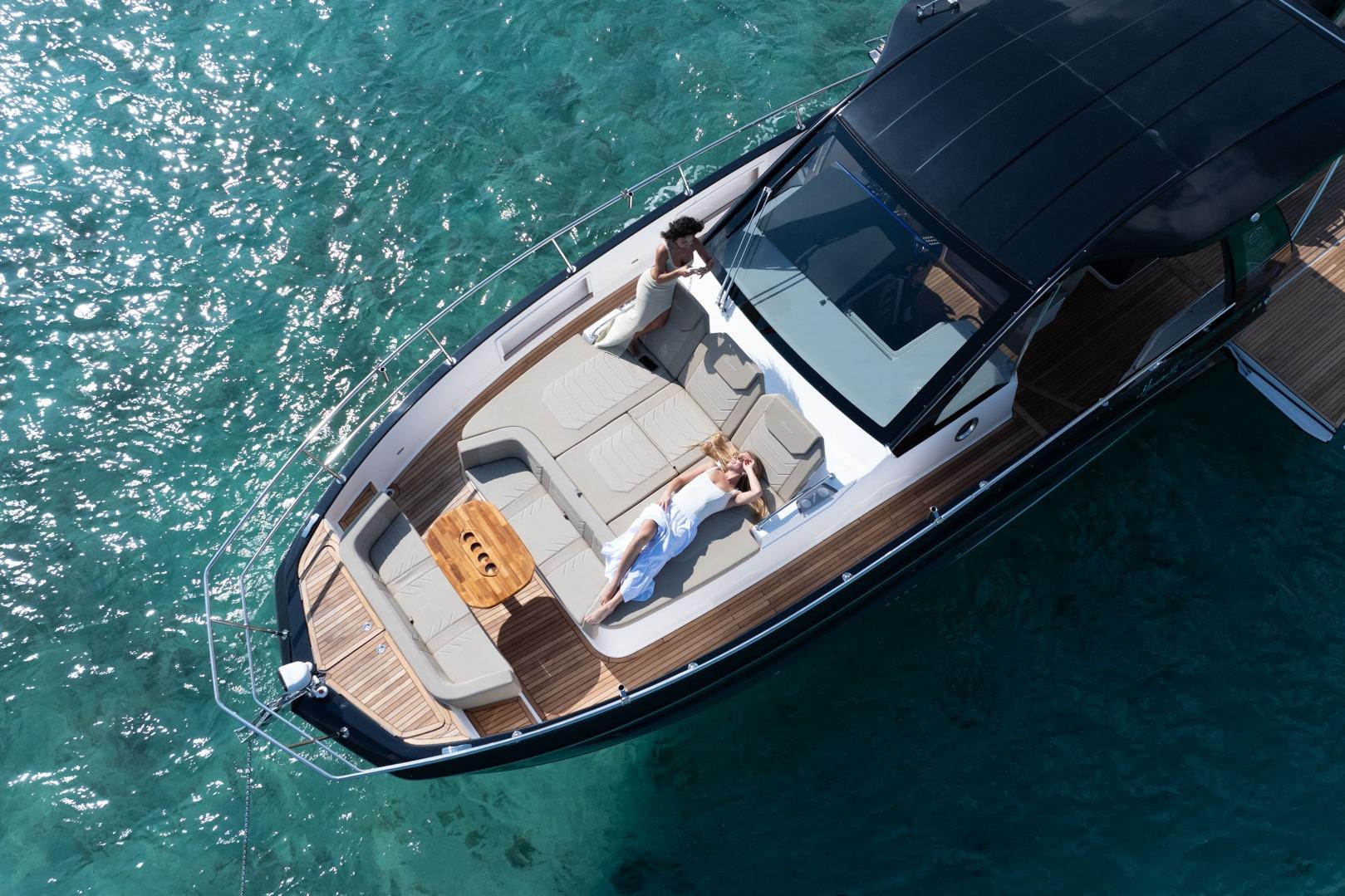 Aerial view of Hanover 447 yacht, 2026 model, with people relaxing on deck in clear blue water.