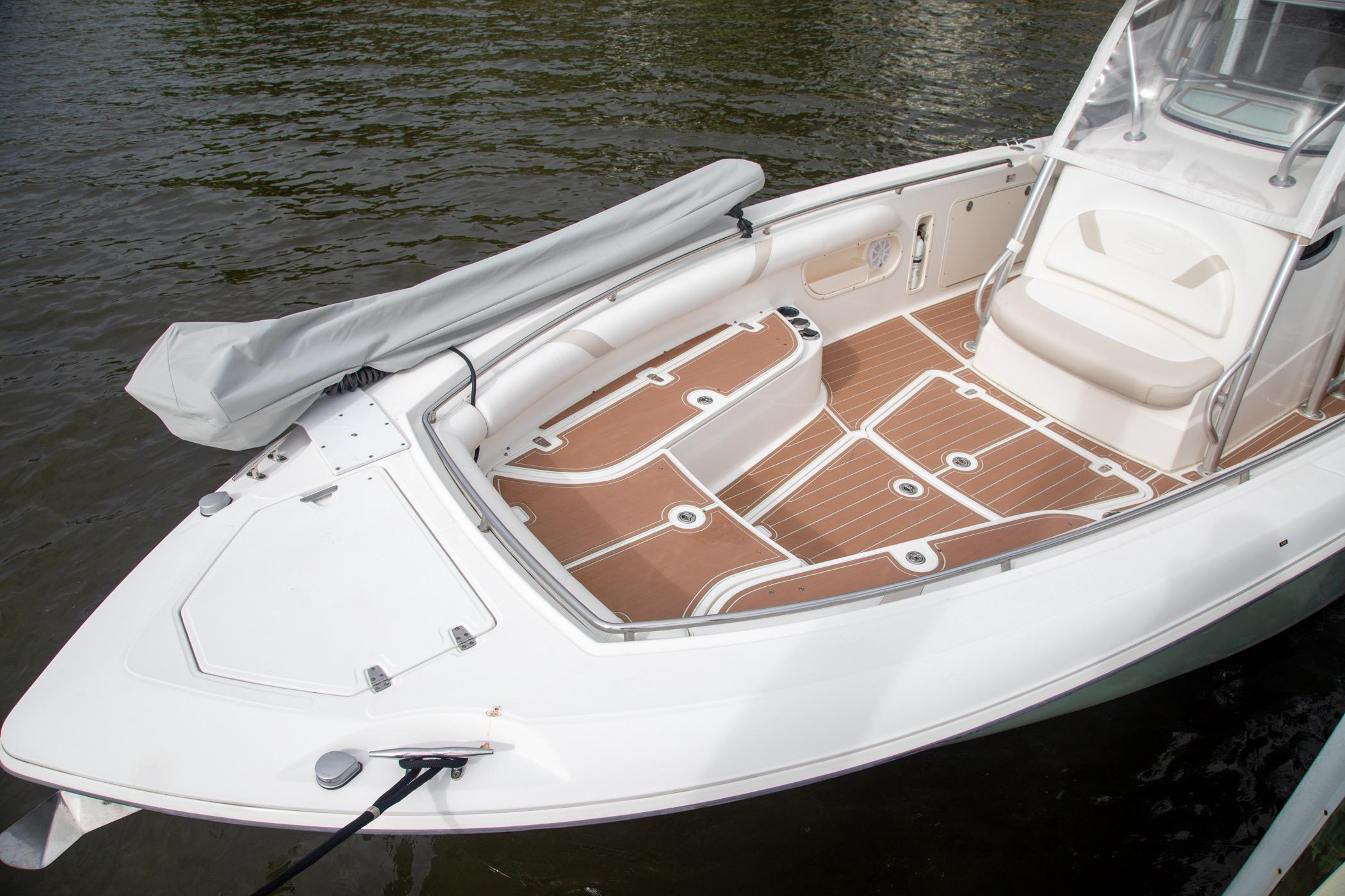 2006 Boston Whaler 320 Outrage boat with spacious deck and seating, docked on water.
