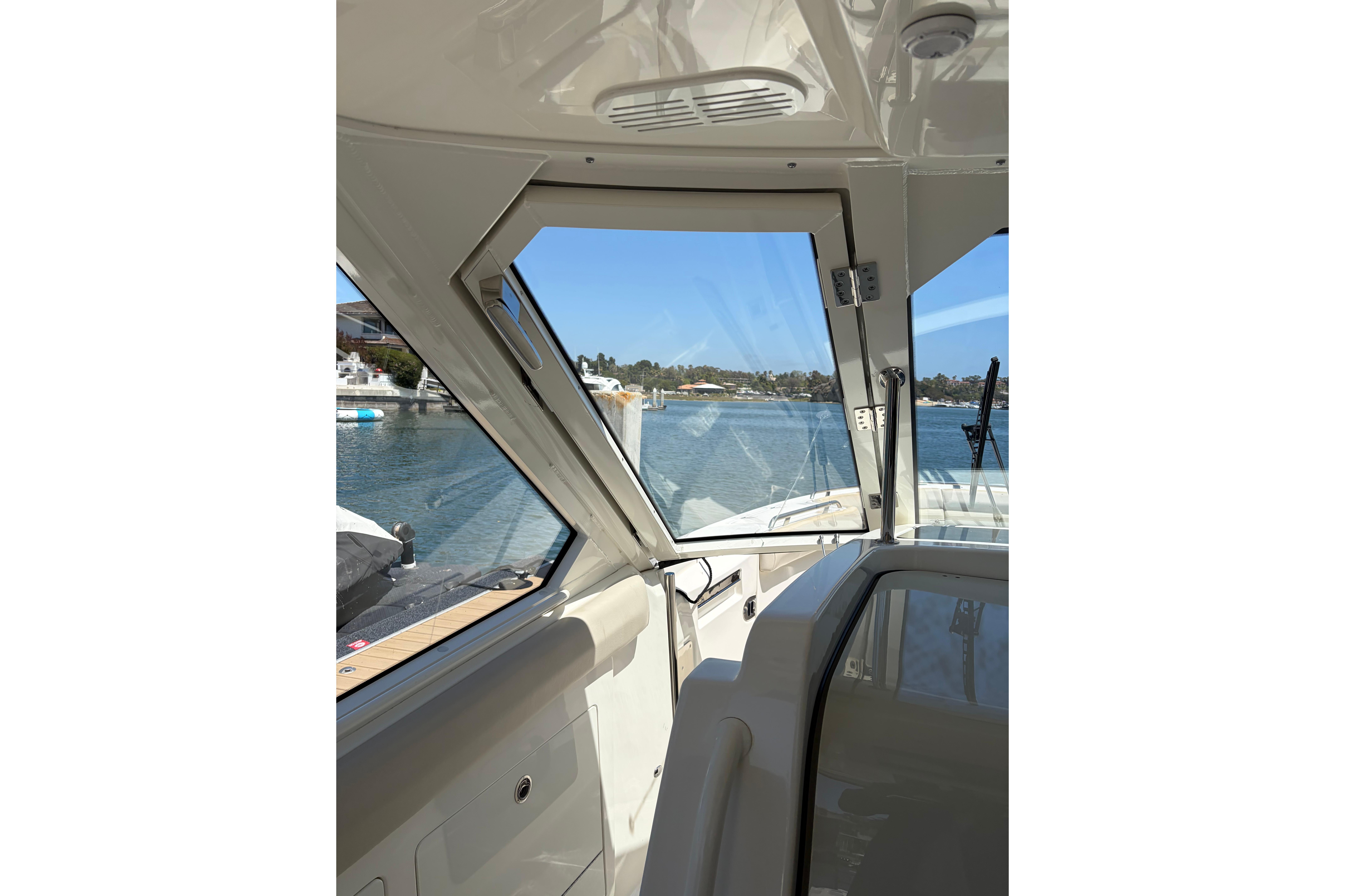 Interior view of 2020 Boston Whaler 380 Realm boat with open window overlooking water.
