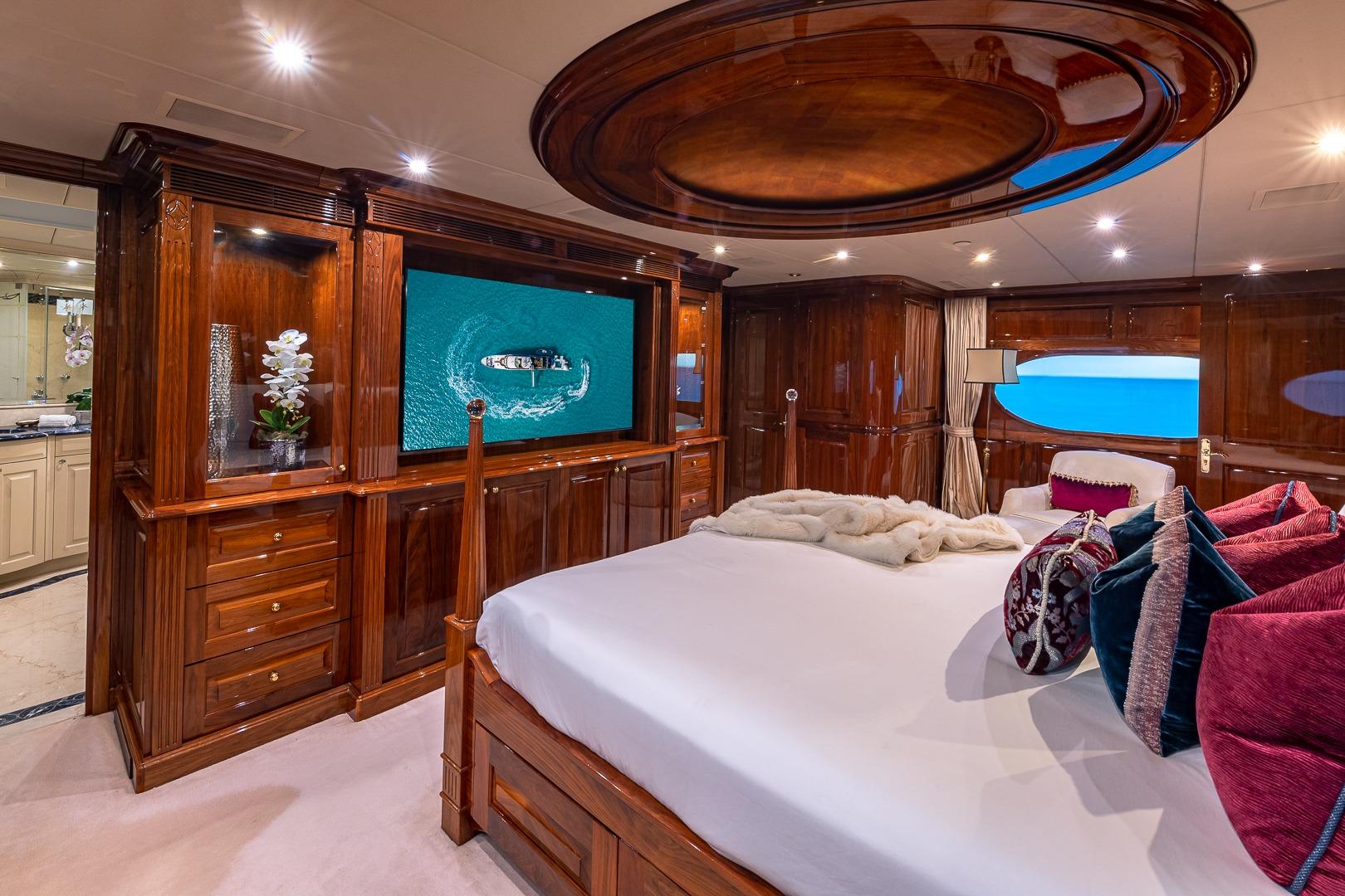 Luxurious 2005 Christensen motor yacht bedroom with elegant wood finishes and ocean view.