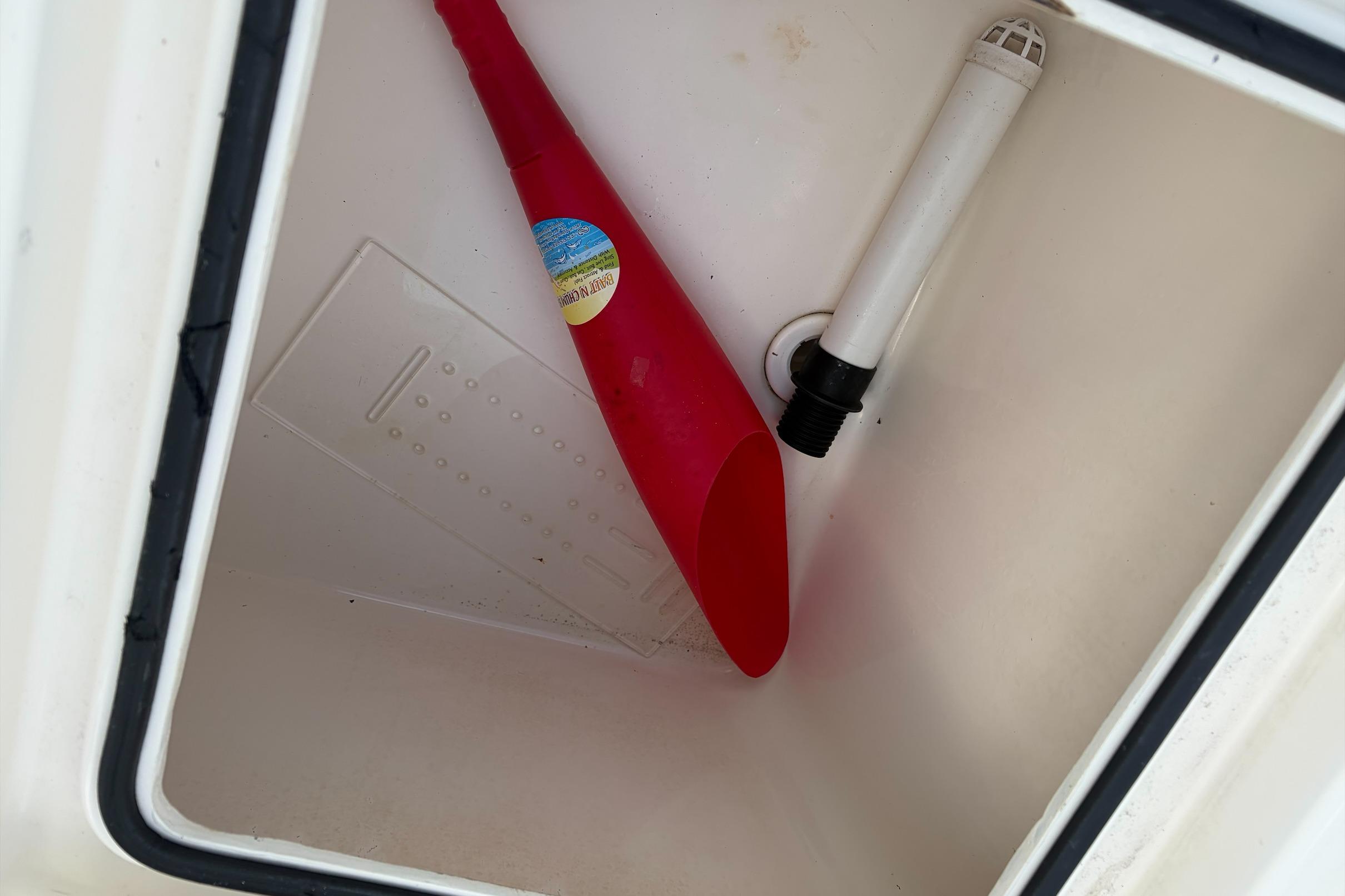 Storage compartment of 2017 Pathfinder 2200 TRS boat with red funnel and pipe.
