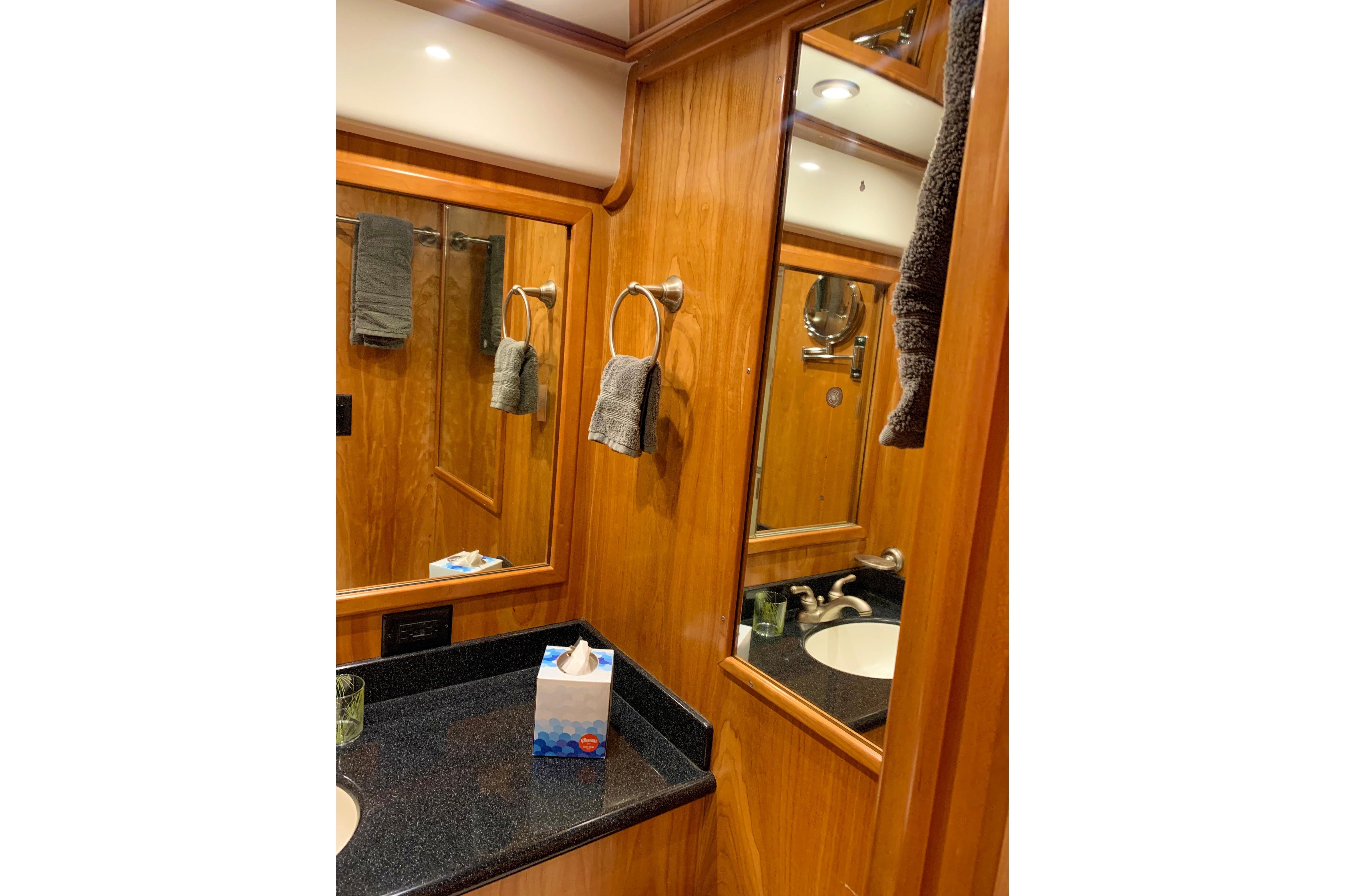 Luxurious wooden bathroom interior on 2007 Navigator 5100 yacht, featuring mirror and sink.