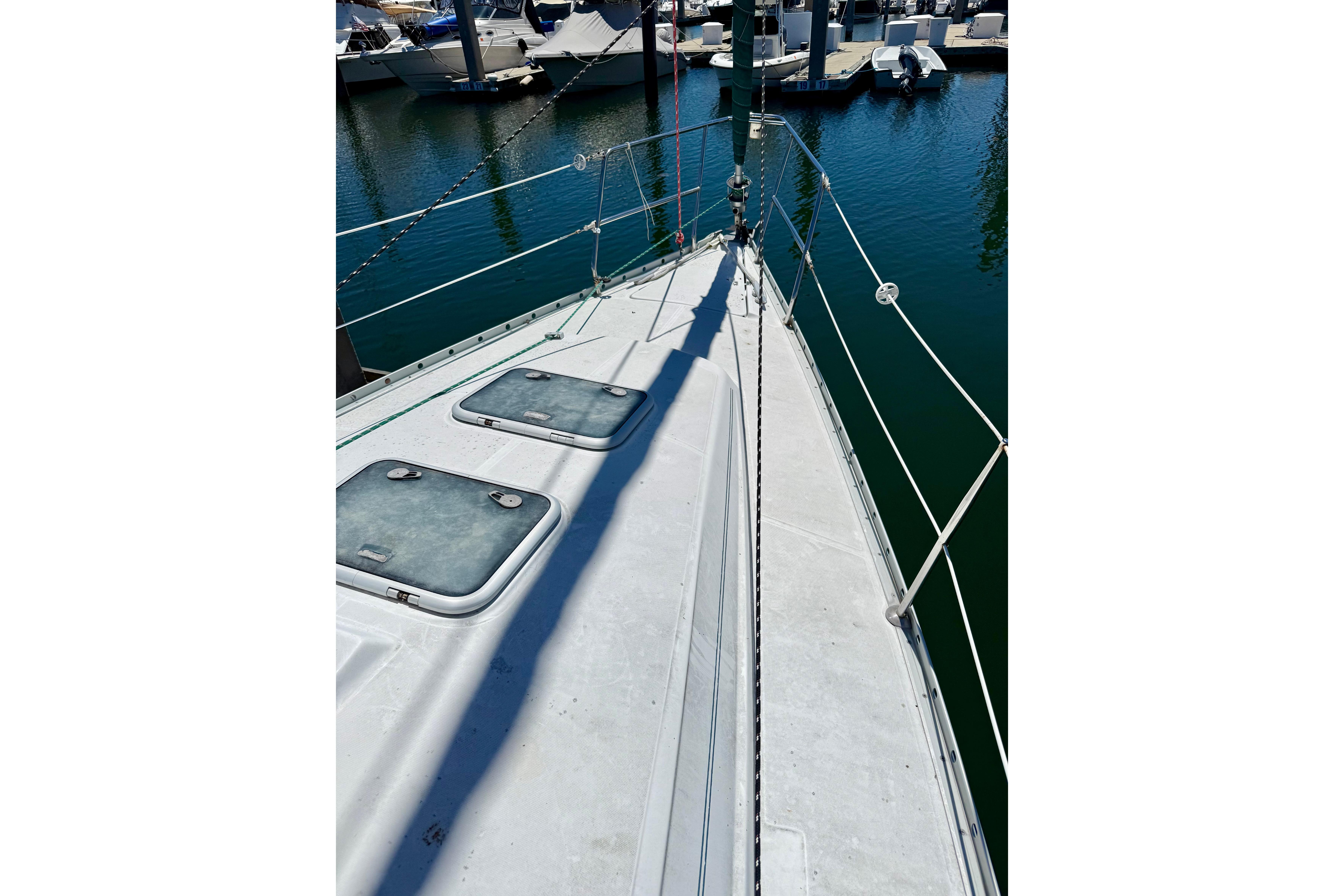 Deck view of a 2002 Beneteau Oceanis Clipper 311 sailboat in a marina.