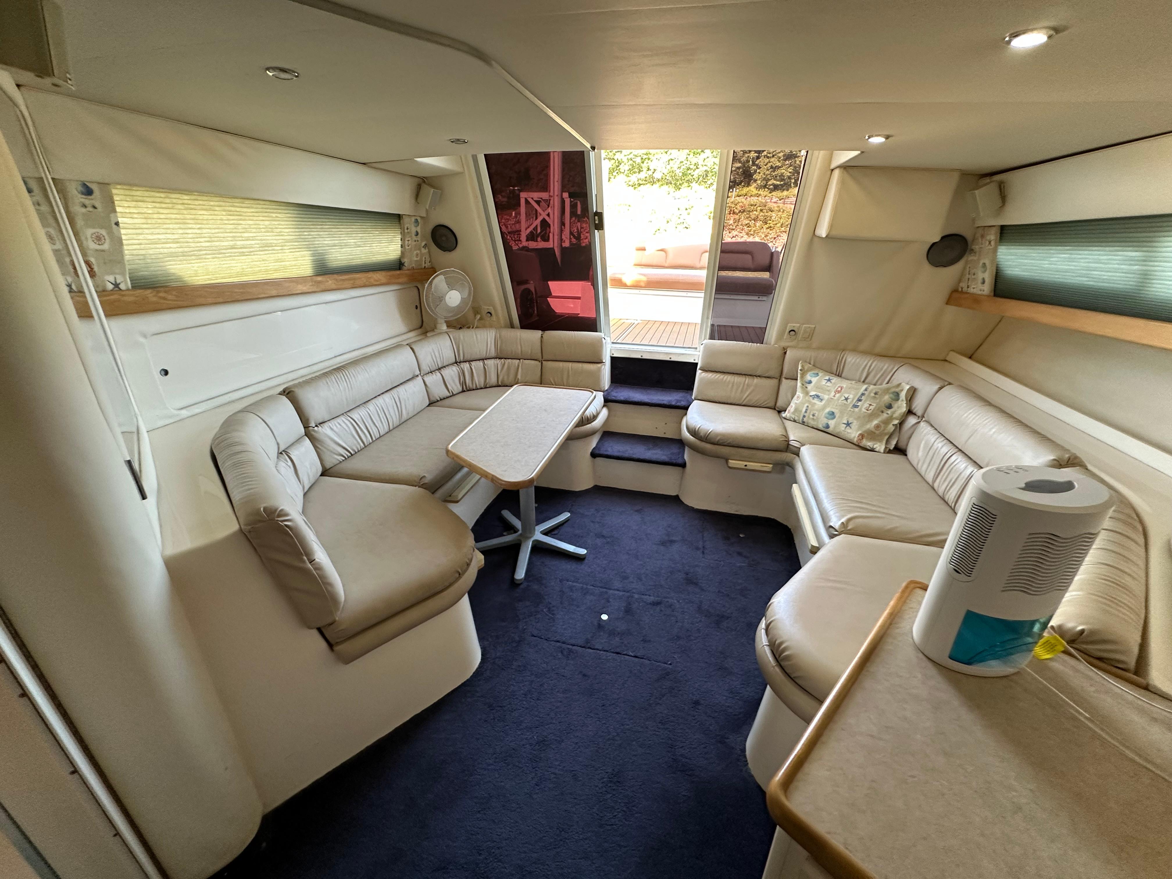 Interior of 1996 Carver 38 Santego yacht with beige seating and table.