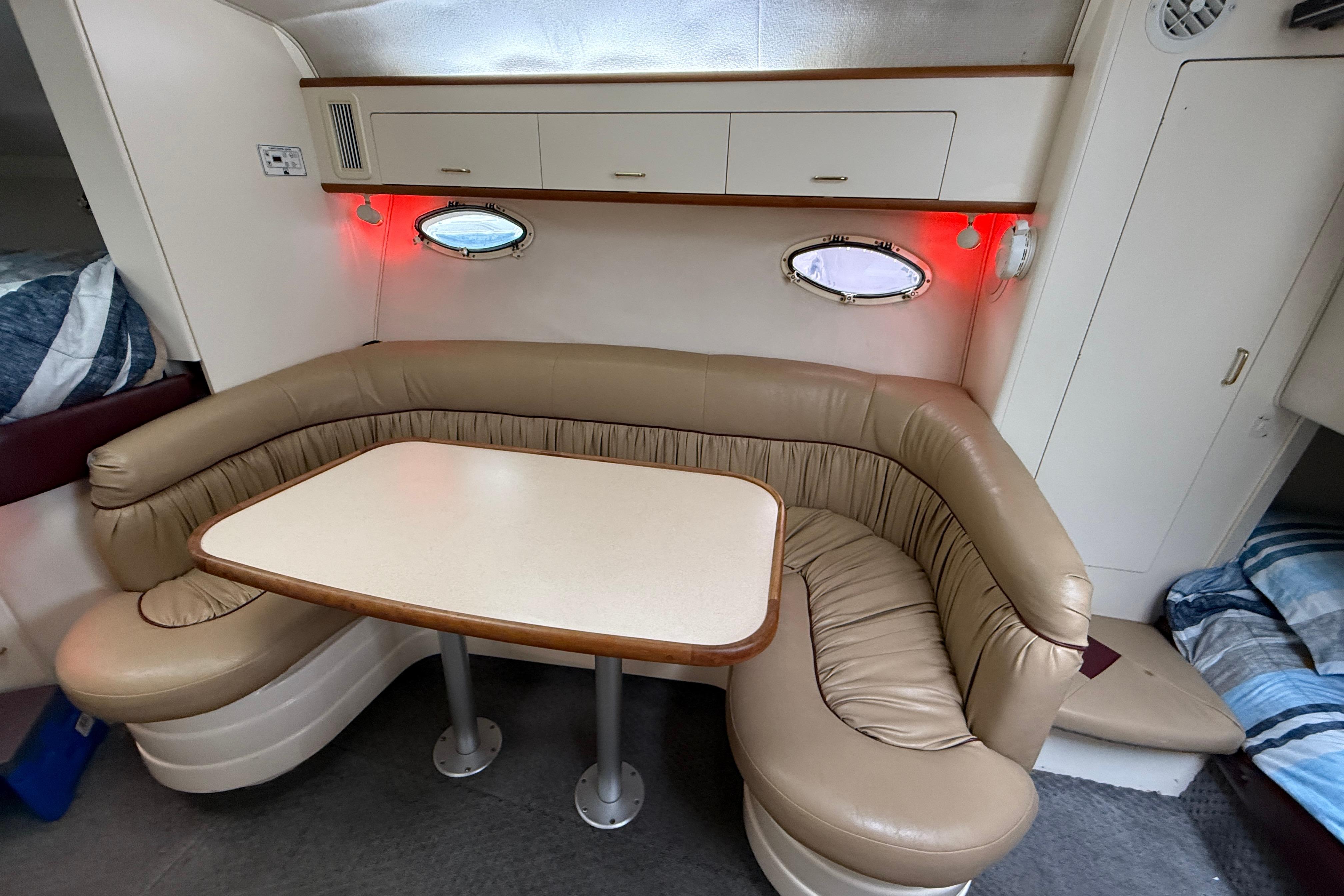 1997 Larson Cabrio 310 Mid-Cabin interior with beige leather seating and dining table.