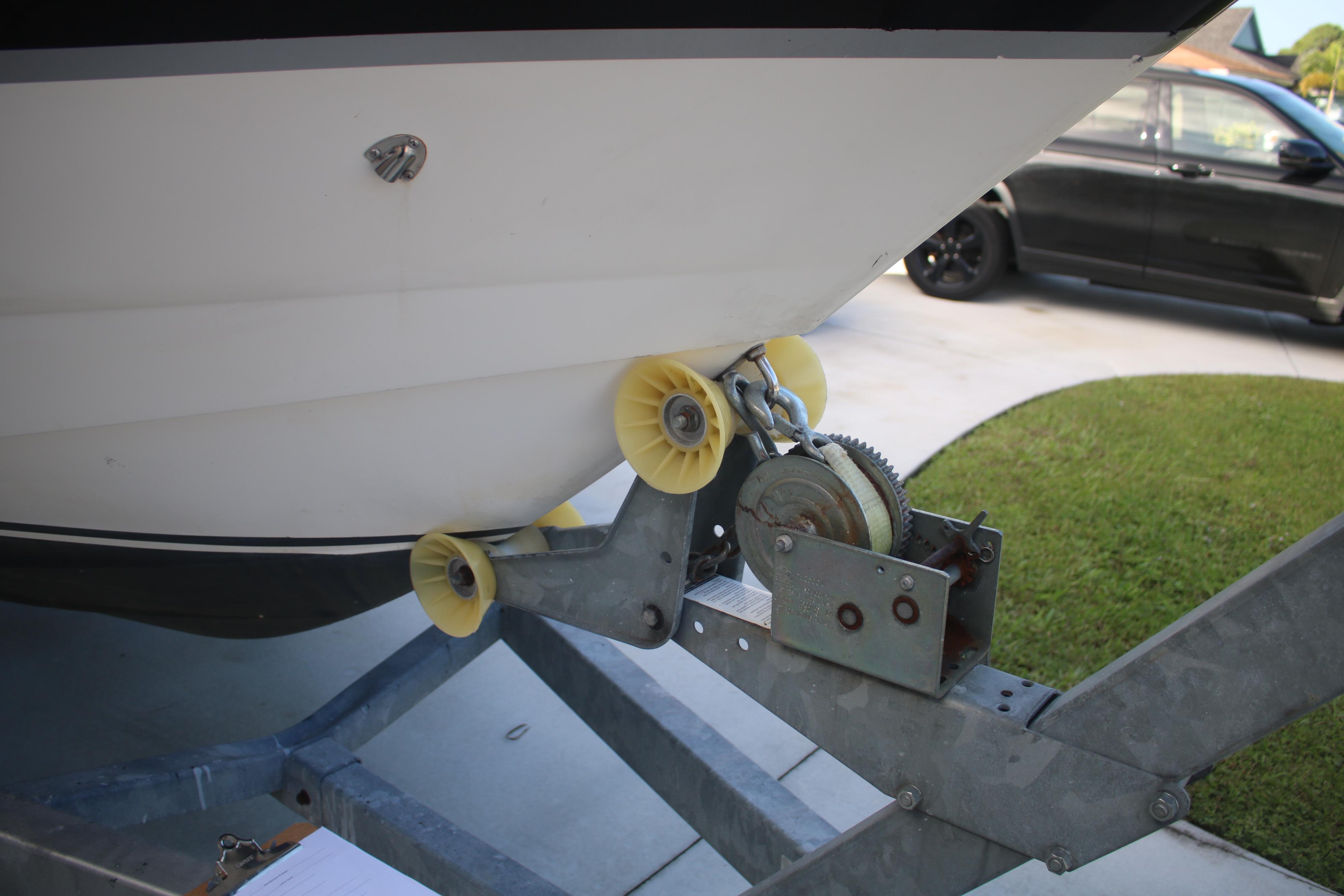 2011 Larson Carbiro 240 boat on trailer with winch and yellow rollers.