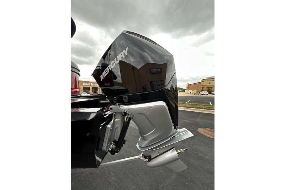 Outboard motor on a 2026 Regency 250 DL boat, parked in a lot.