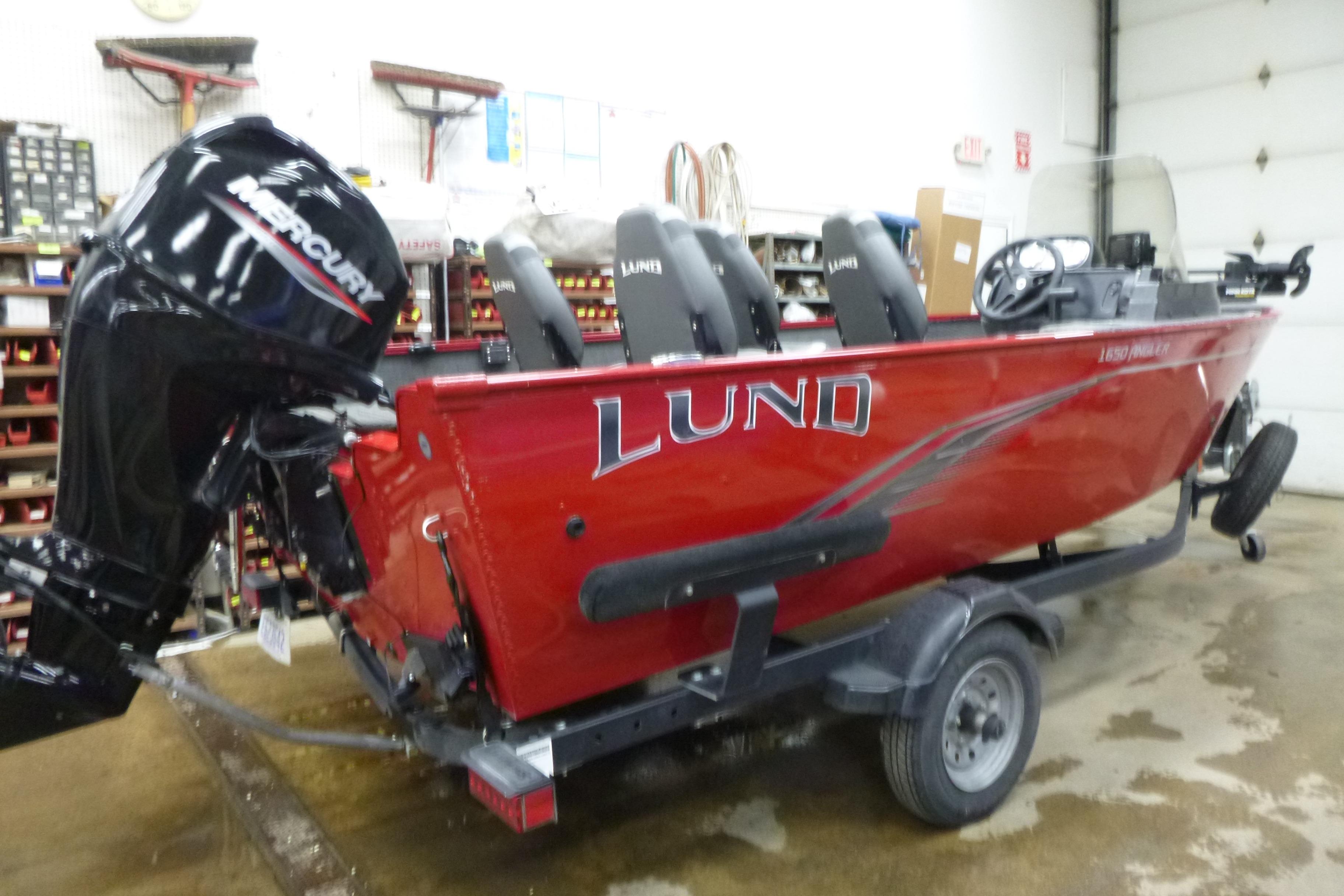 2022 Lund 1650 Angler Sport boat with Mercury engine in a garage setting.