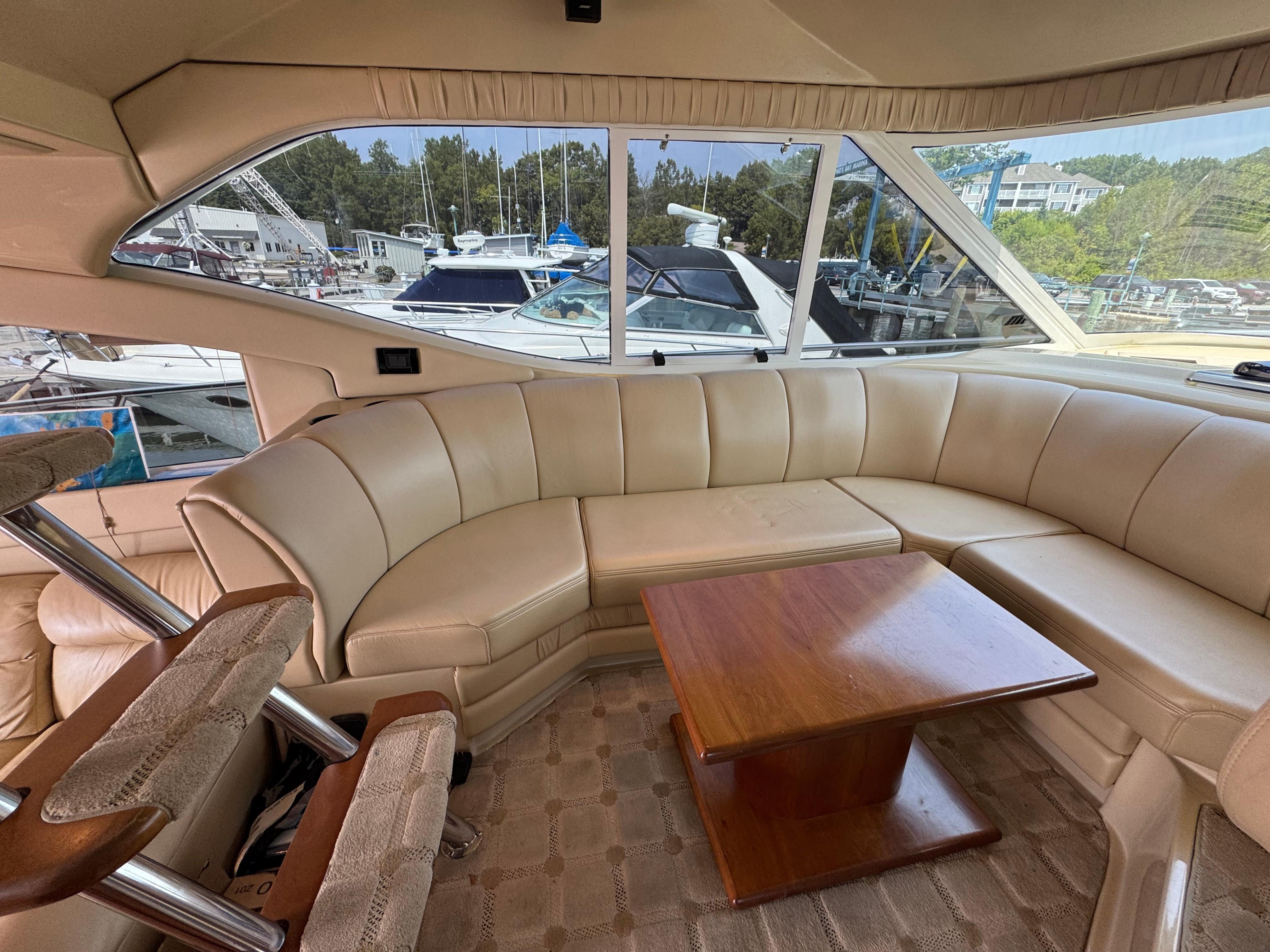 Luxurious interior of 2003 Cruisers Yachts 5000 Sedan Sport with leather seating and wooden table.