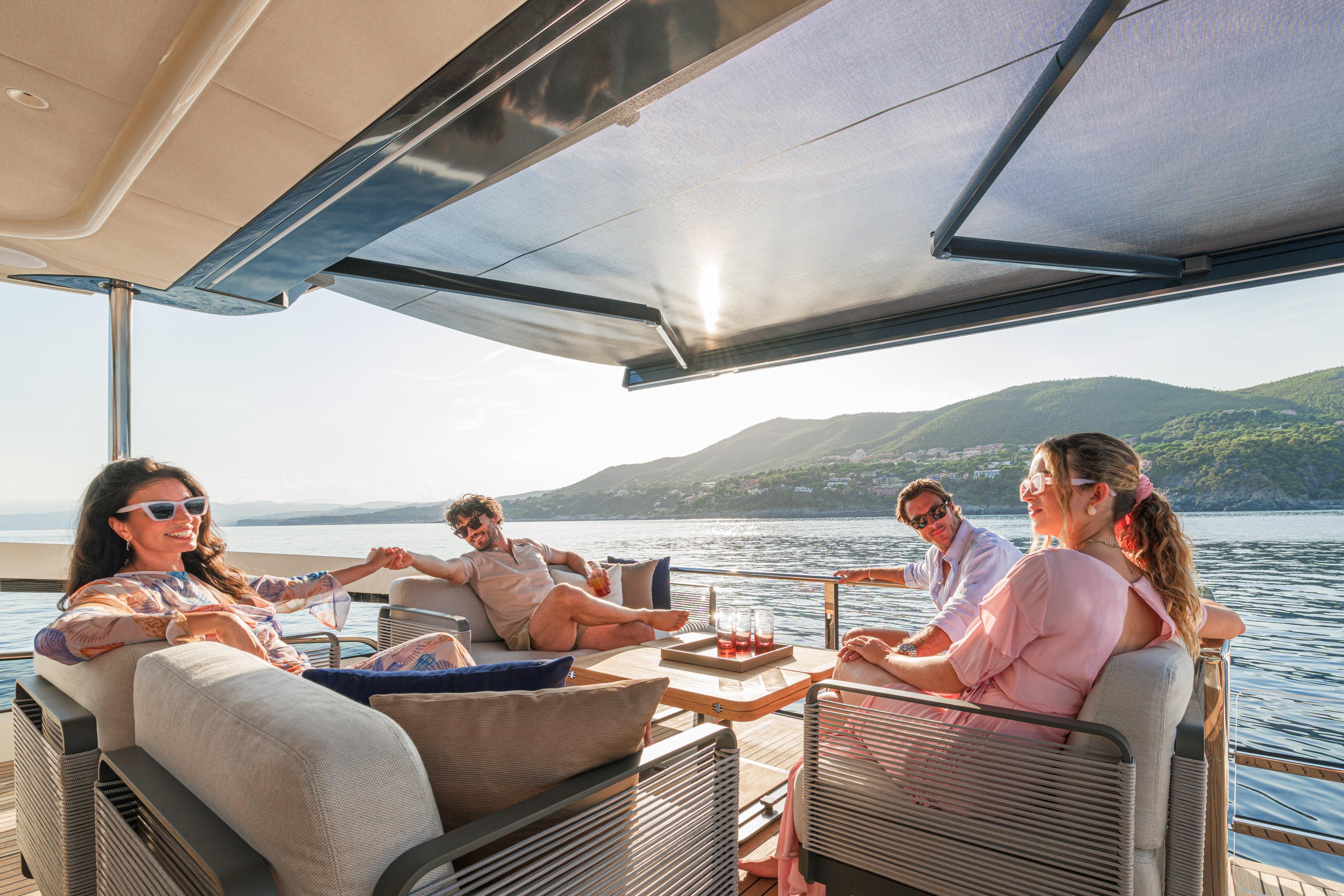 People relaxing on the 2026 Absolute Navetta 62 yacht, enjoying a scenic ocean view.