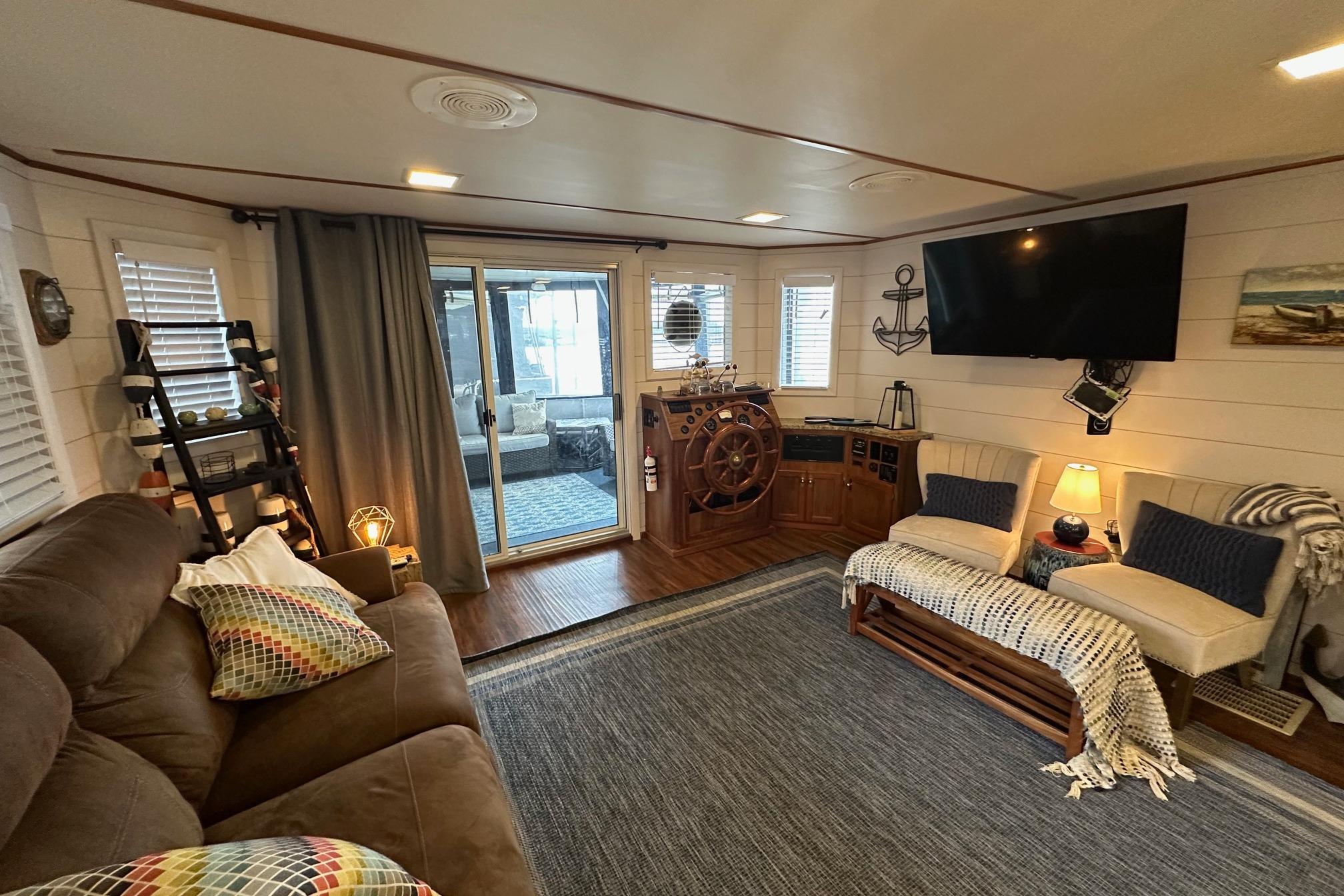 Cozy 1996 Lazy Days houseboat interior with nautical decor, plush seating, and large TV.