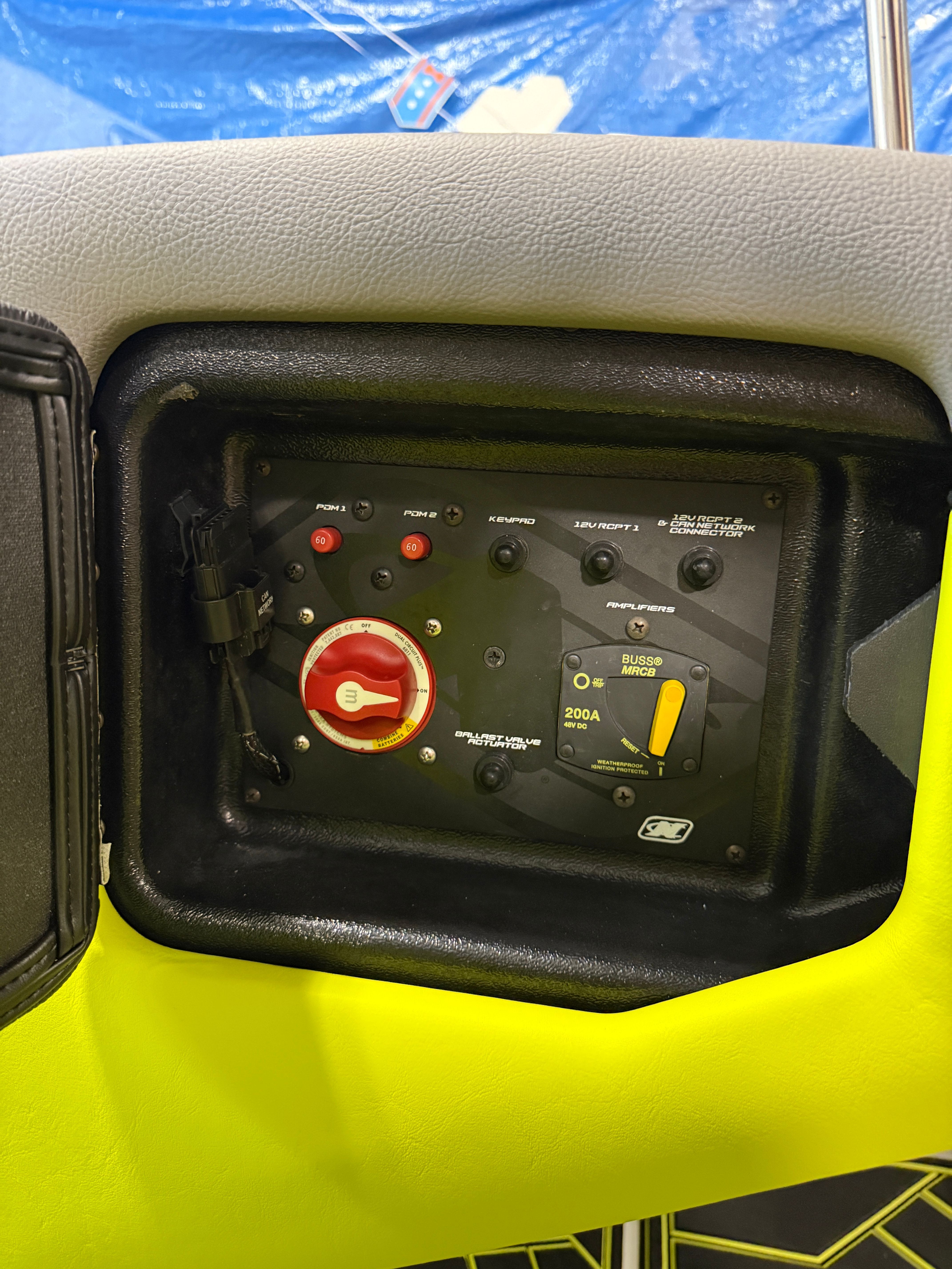 Close-up of a boat control panel with switches and a red rotary knob.