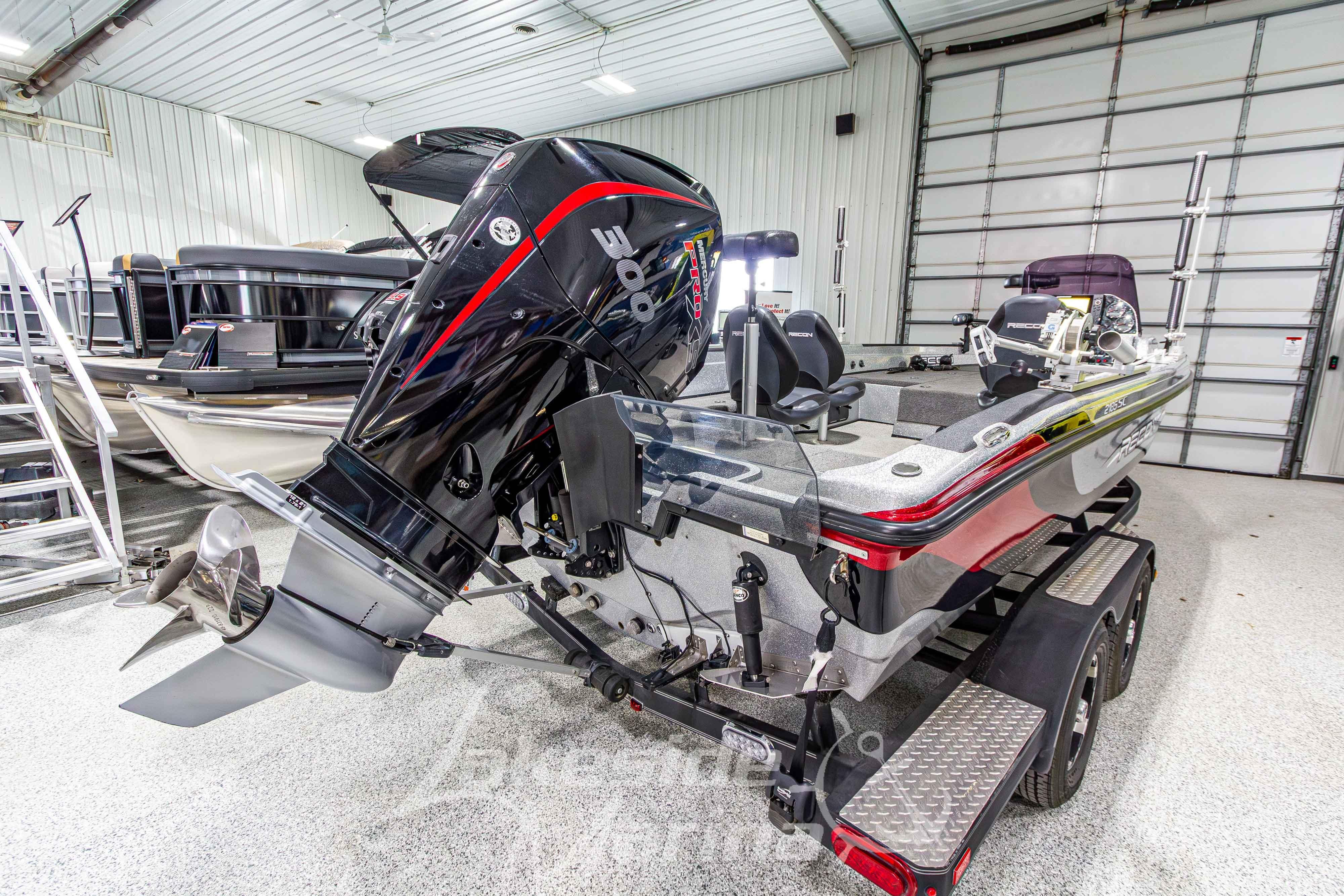 2019 Recon 2185 SC boat with powerful outboard motor in a spacious garage.