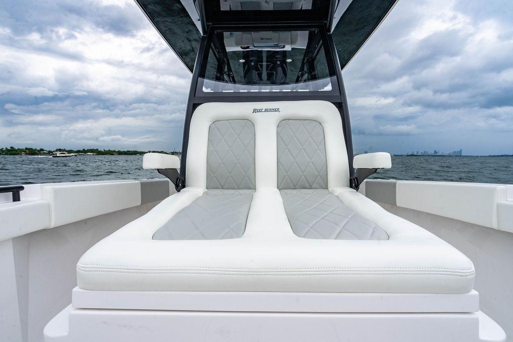 Luxurious seating on 2027 Reef Runner 280 boat with ocean backdrop.