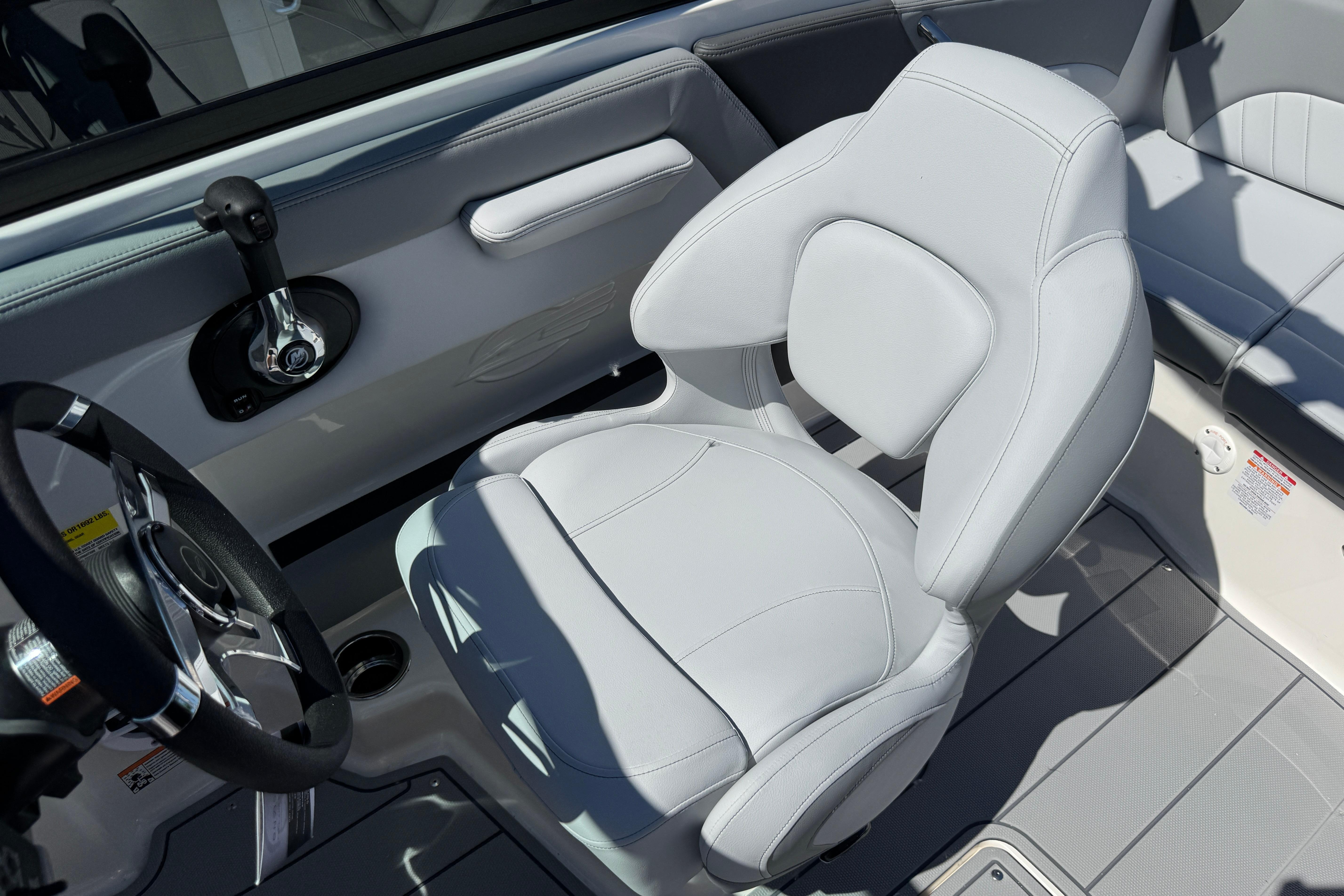 Interior of 2026 Chaparral 21 SSi boat featuring sleek white captain's chair and steering wheel.