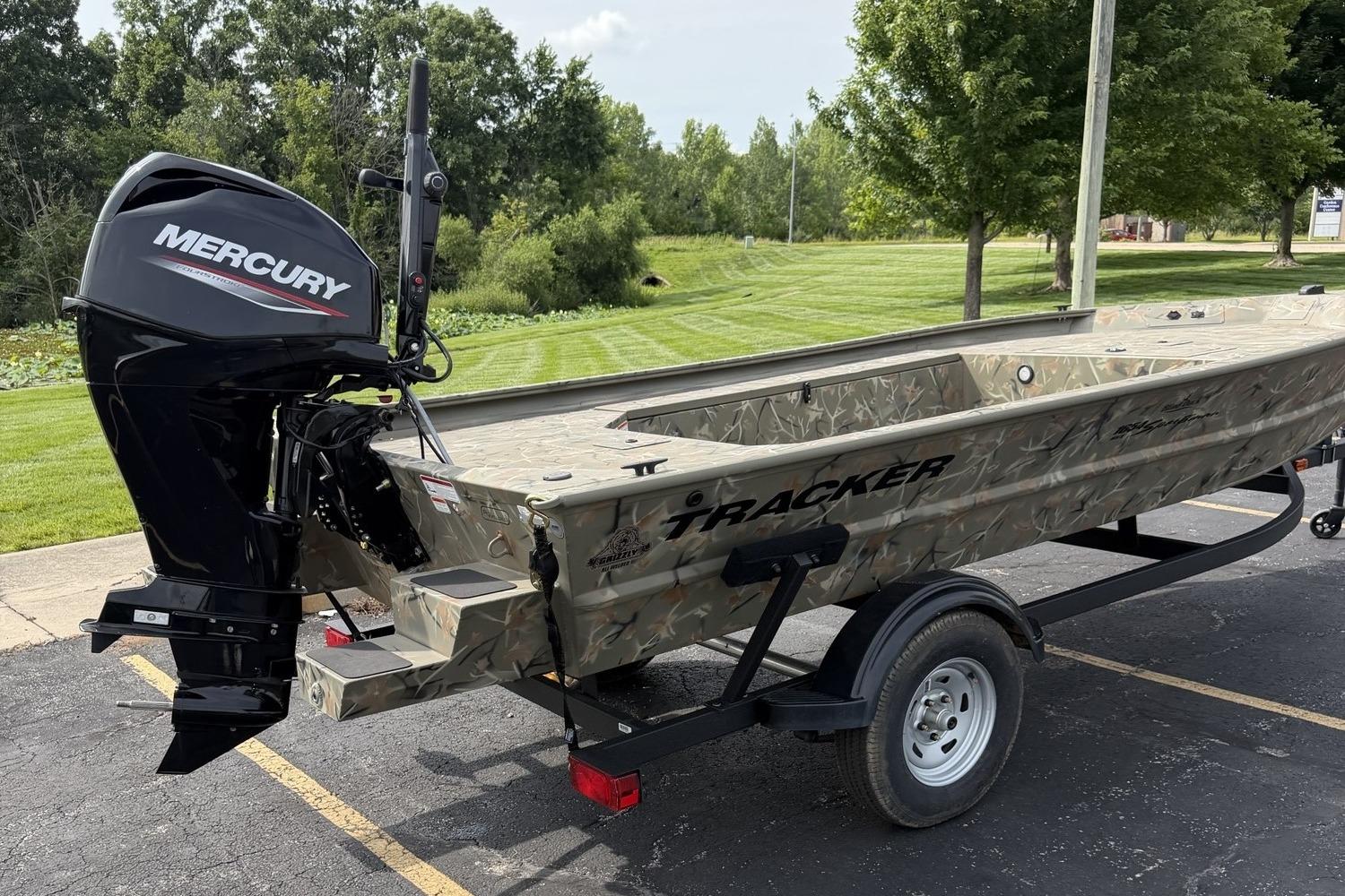 2025 Tracker Grizzly 1654 T Sportsman boat with Mercury engine on trailer.