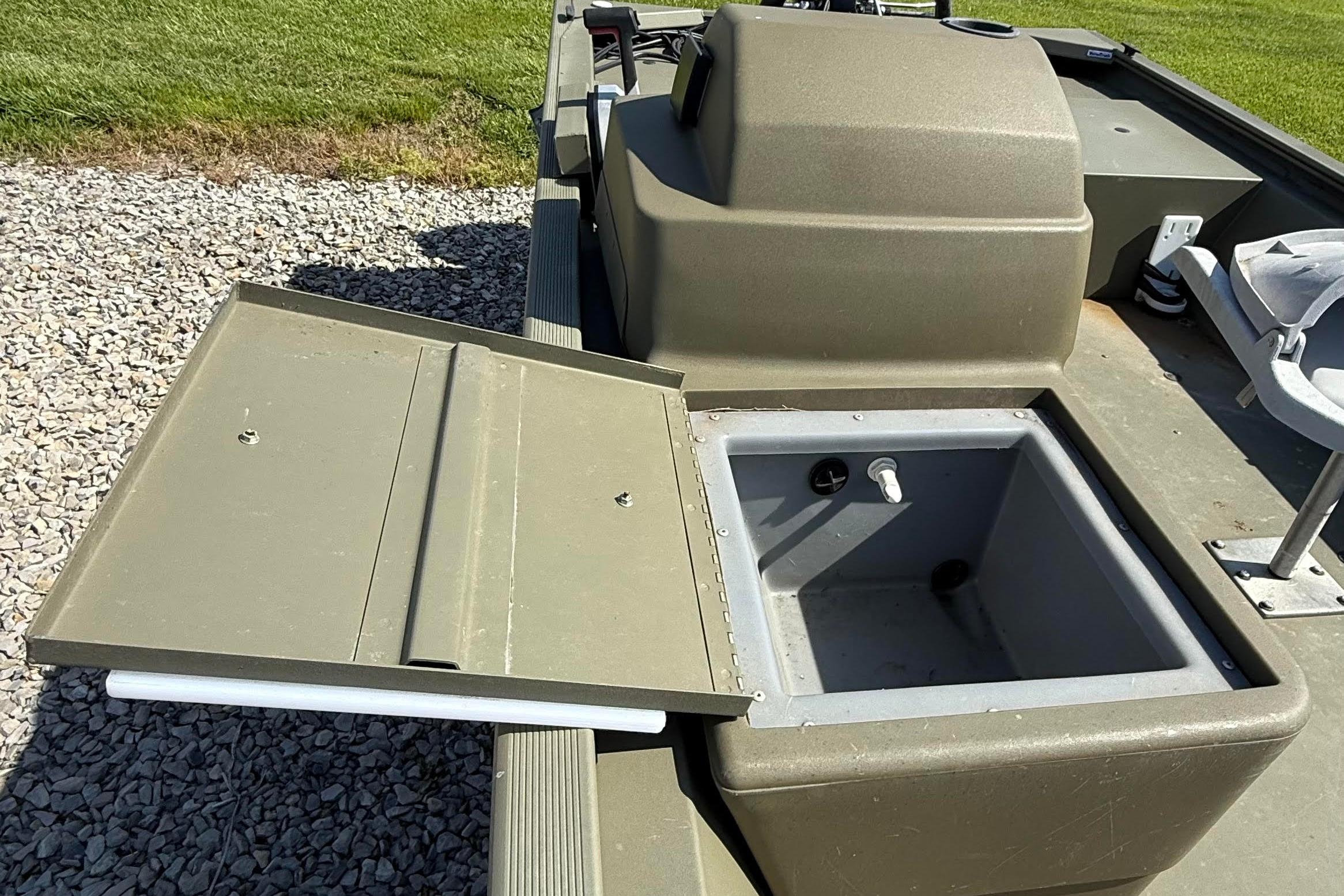 2019 Tracker Grizzly 1648 SC boat with open storage compartment on deck.