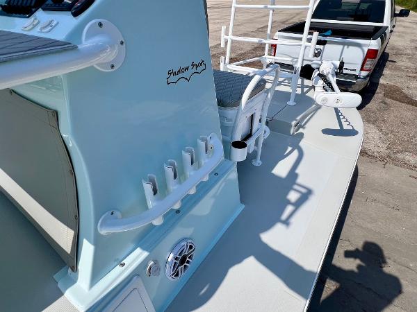 2022 Shallow Sport 20 Classic boat with fishing rod holders and console, parked near a truck.