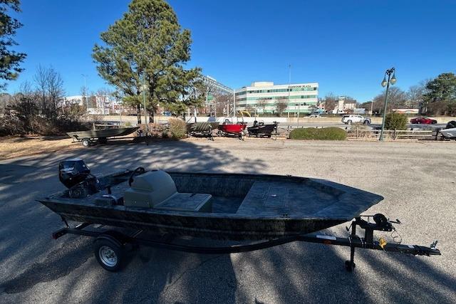 2026 Tracker Grizzly 1648 SC boat on trailer in parking lot, sunny day.