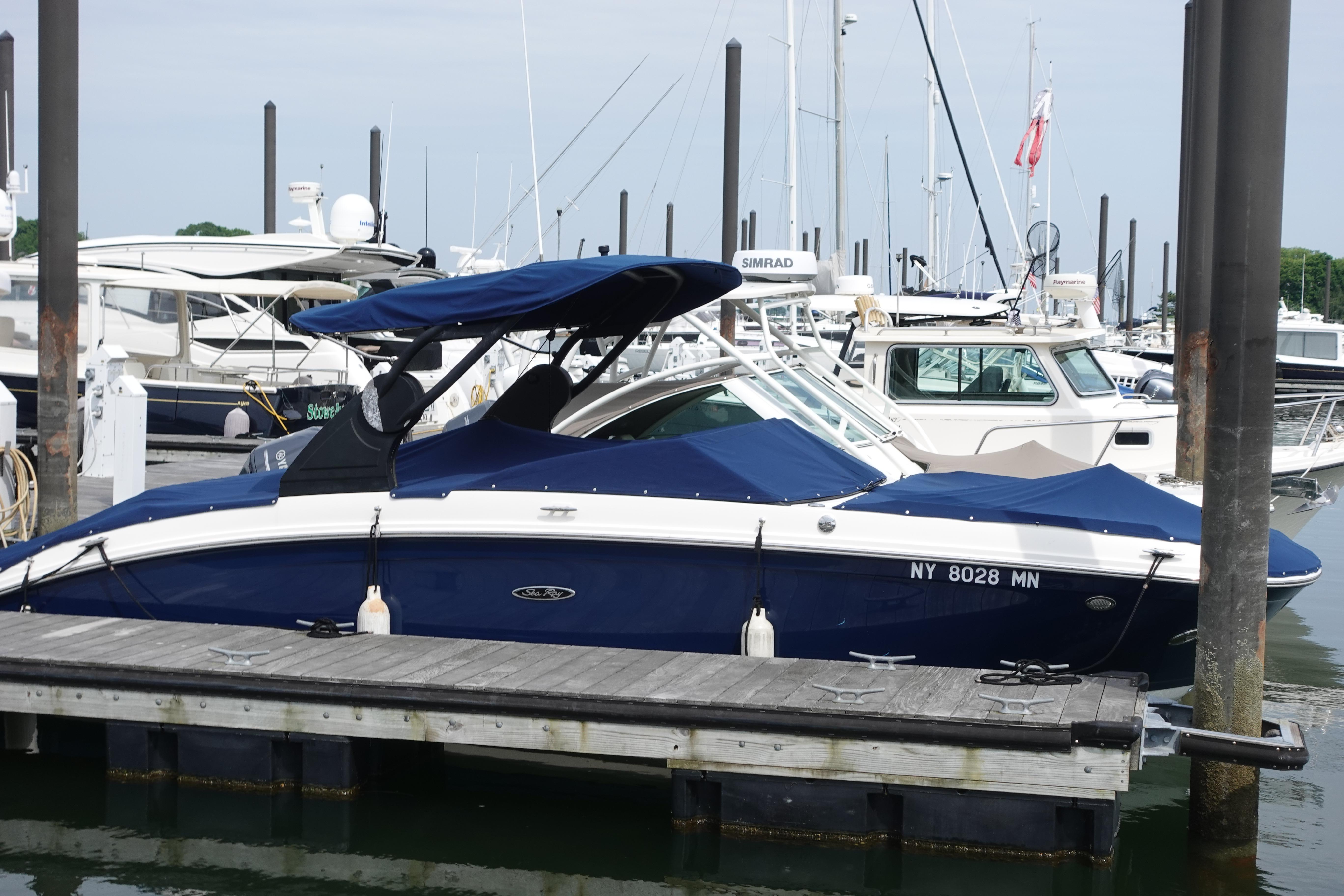 2018 Sea Ray SDX 270 boat docked at marina, blue cover, calm water.