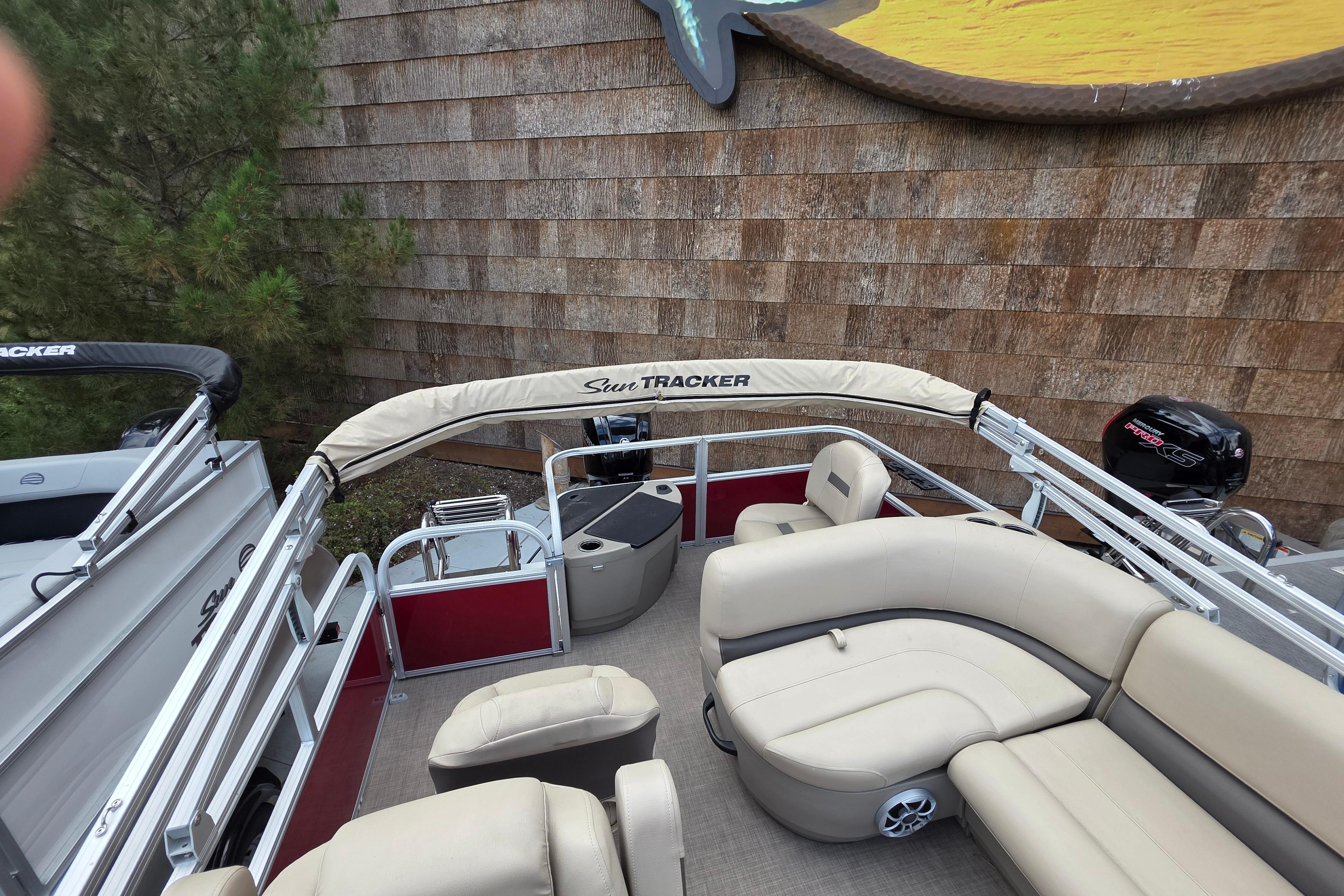 2025 Sun Tracker Bass Buggy 18 DLX pontoon boat with beige seating and canopy.