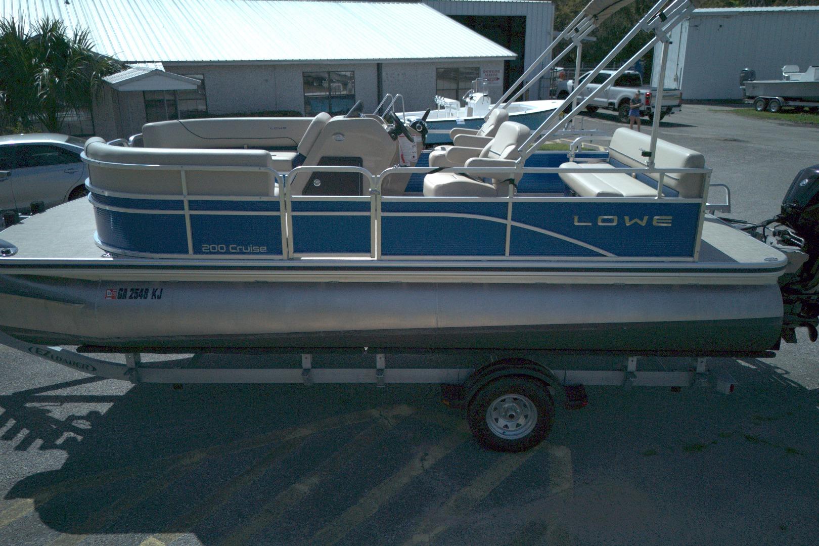 2024 Lowe Ultra 200 Cruise pontoon boat on trailer in a parking lot.