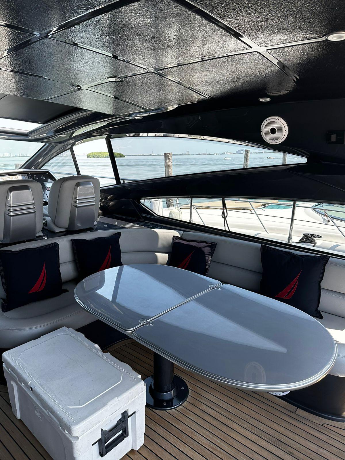 Luxurious 2009 Pershing 56 yacht interior with sleek seating and modern table design.