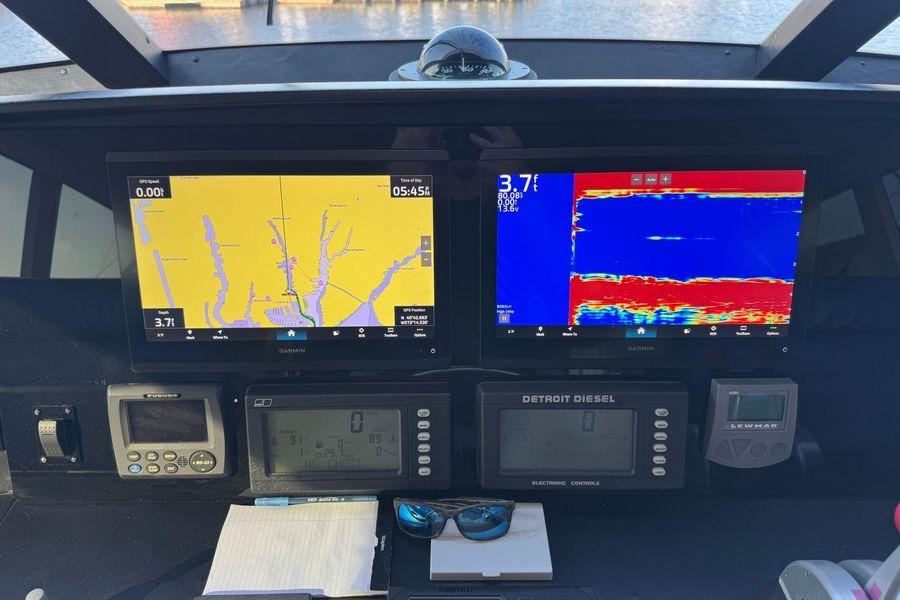 Control panel of a 2002 Viking 61 Enclosed Bridge with navigation and sonar displays.