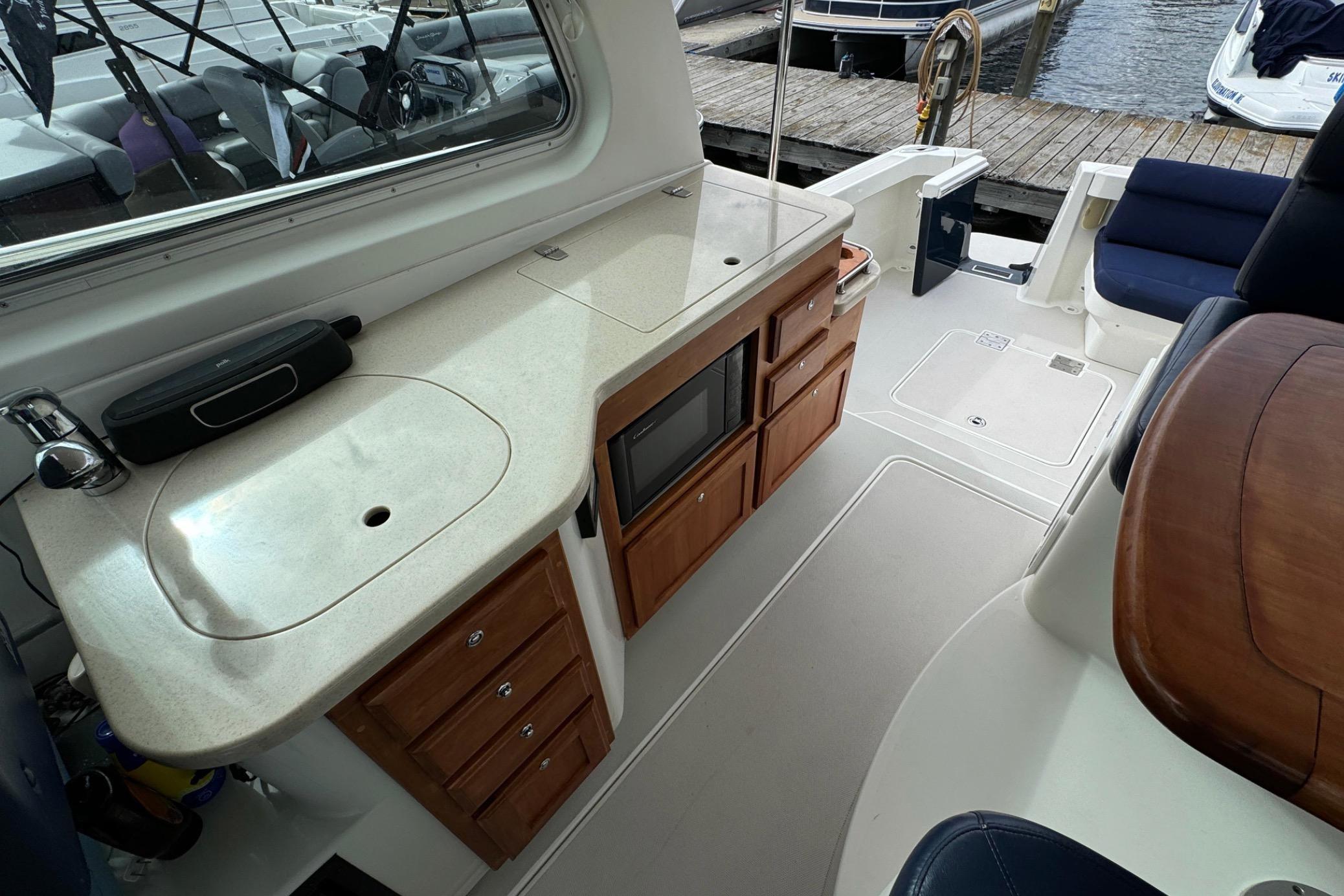 2008 Back Cove 33 yacht interior with kitchenette, sink, and seating area by the dock.