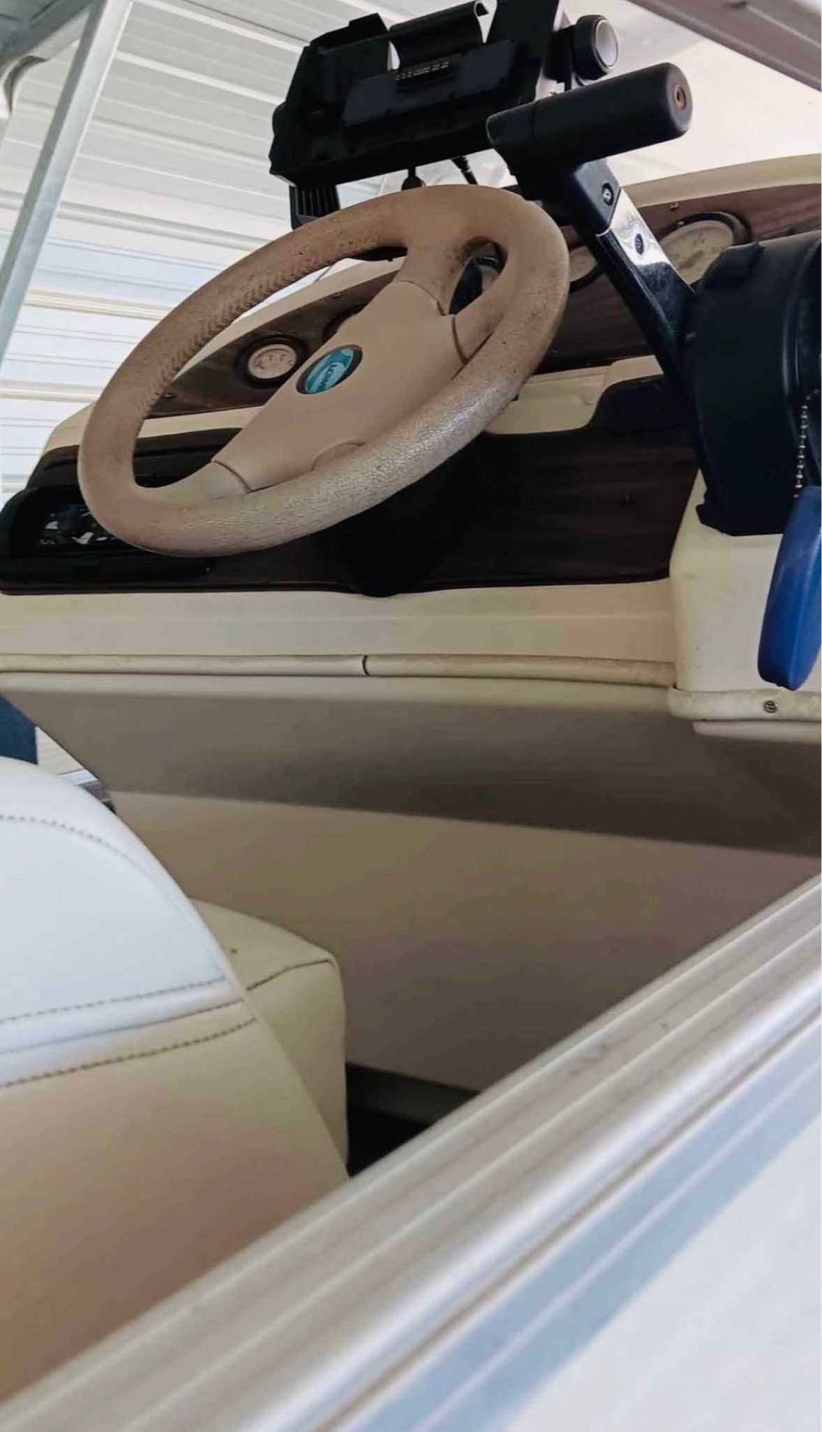 Close-up of a boat's helm with steering wheel and instruments.