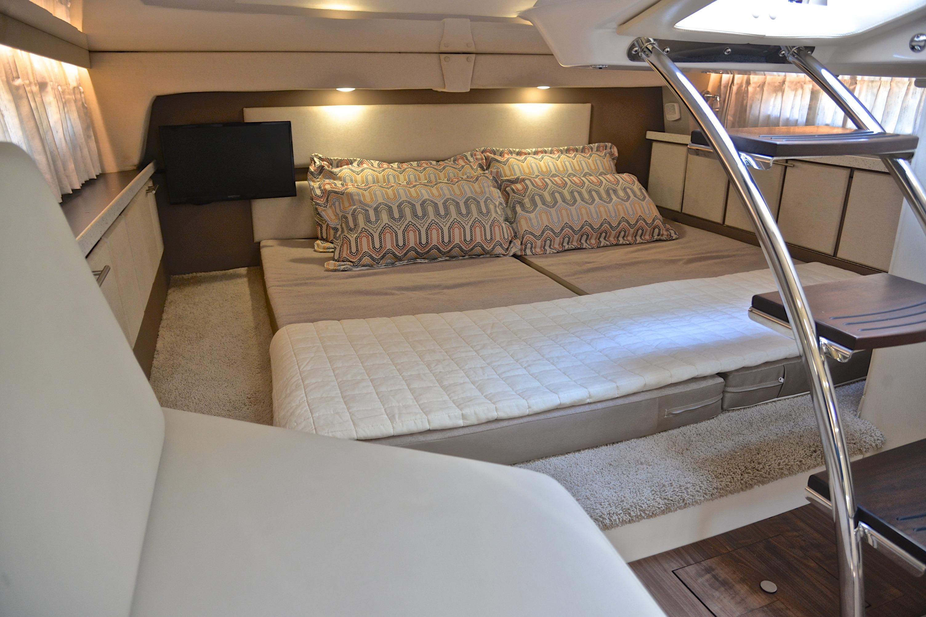 Luxurious interior cabin of 2018 Regal 33 Express yacht with cozy bedding and modern decor.