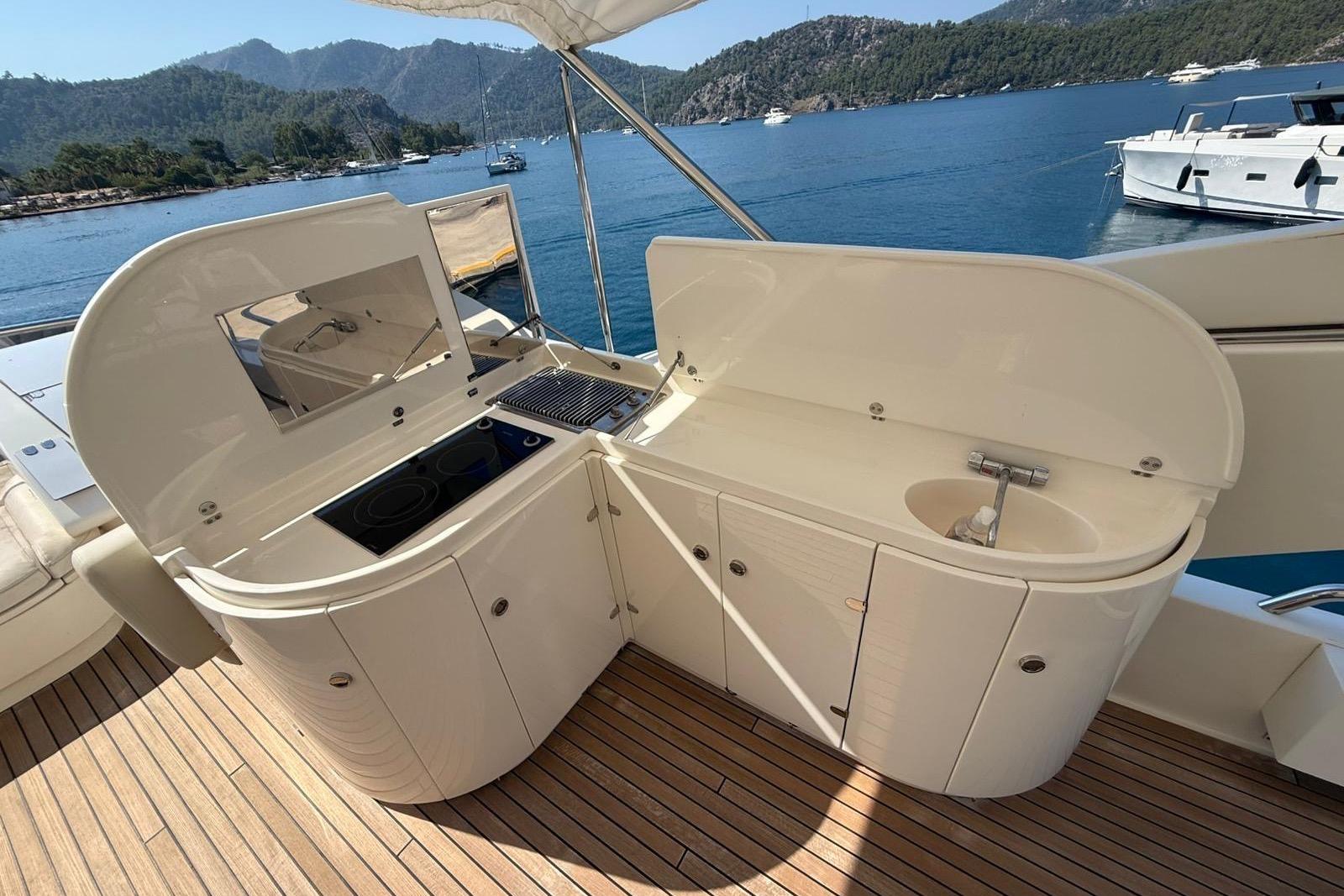 Outdoor kitchen on 2008 Evo Marine Deauville 76 yacht, featuring stove and sink, with scenic ocean view.