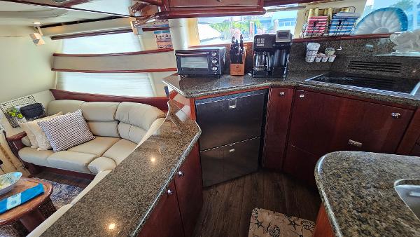 Luxurious 2005 Neptunus 56 Flybridge yacht interior with modern kitchen and cozy seating area.