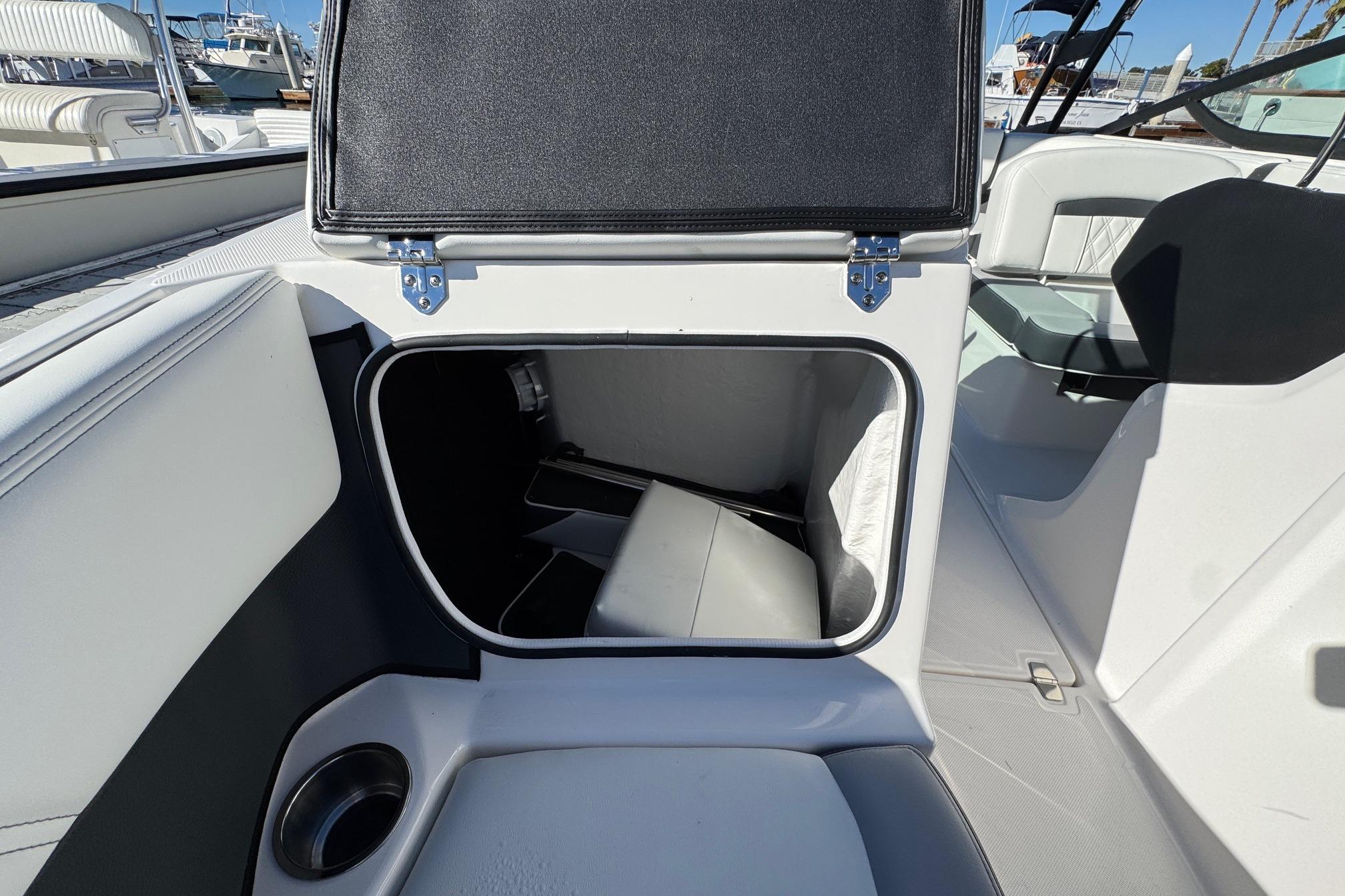 2026 Regal 21 OBX boat interior storage compartment with open hatch and cup holder.