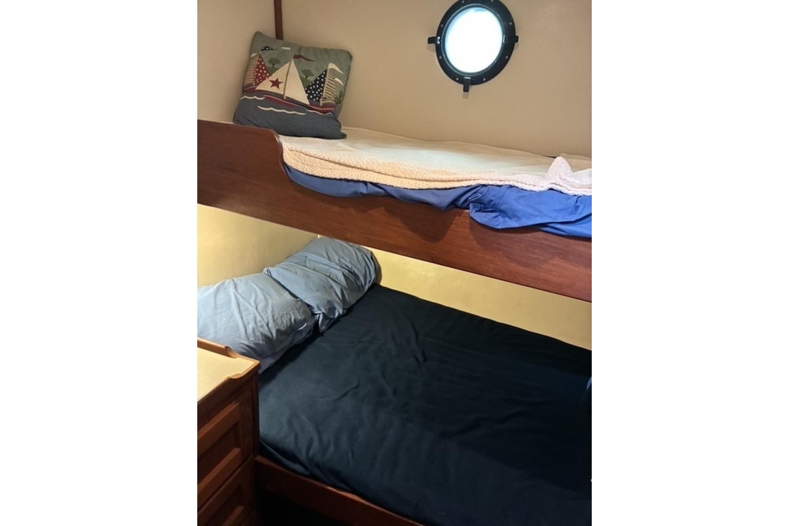 Cozy bunk beds in a 2000 Nordic Tug 37 cabin with nautical-themed decor.