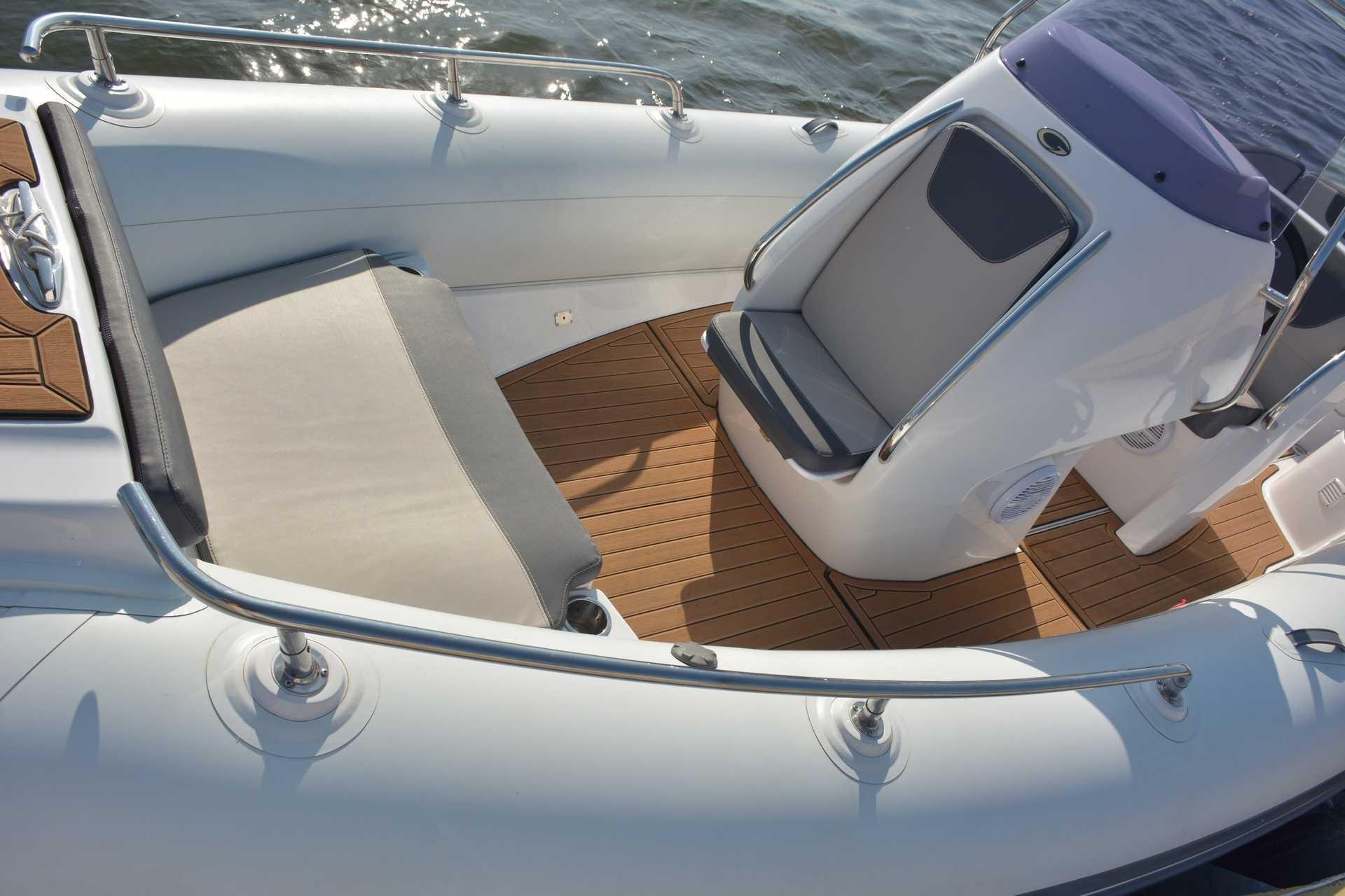 2024 Grand Inflatables G650 boat interior with cushioned seating and teak flooring.