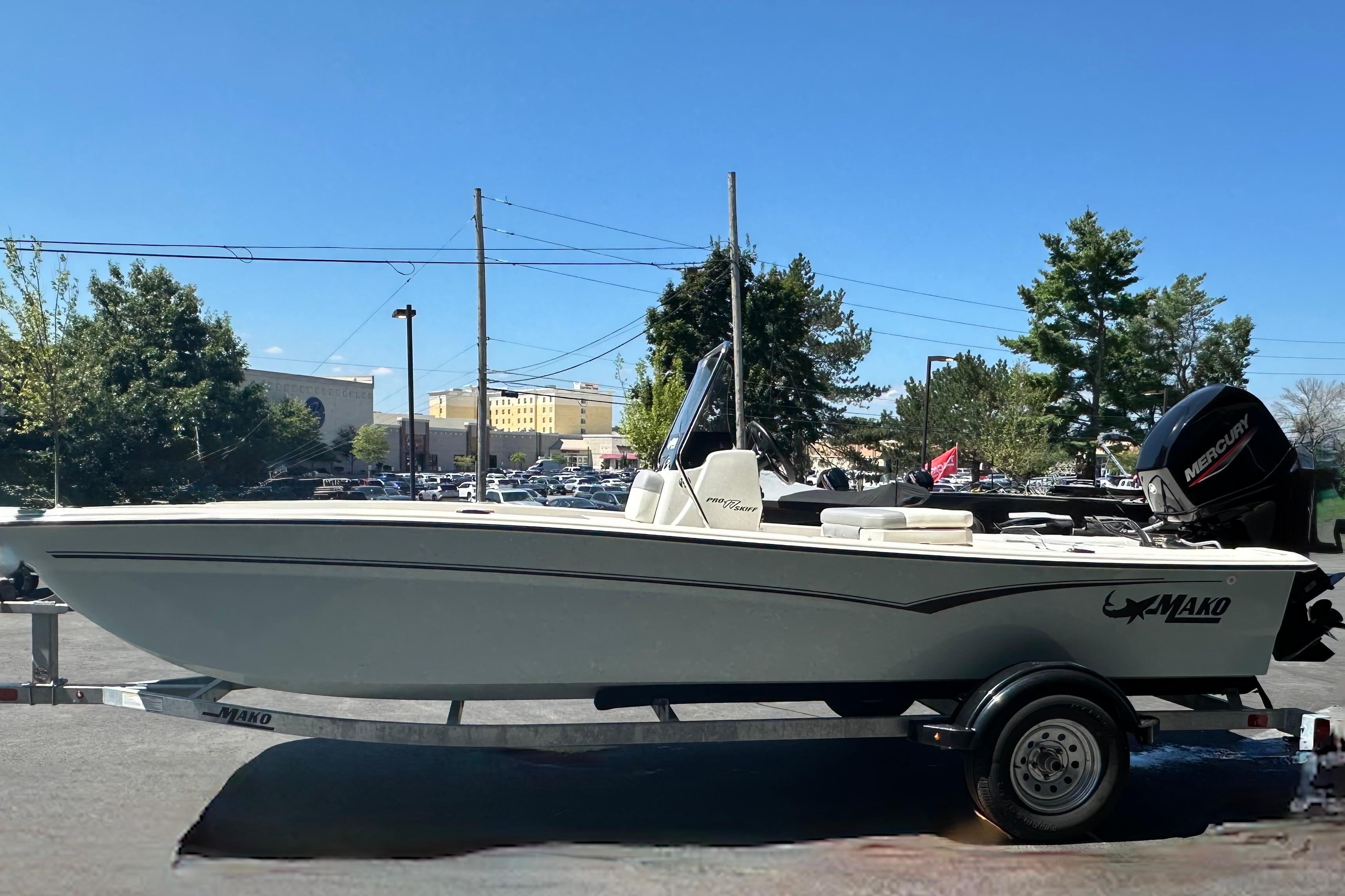 2026 Mako Pro Skiff 17 CC boat on trailer, parked outdoors under clear blue sky.