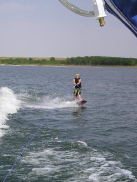 Person wakeboarding behind a 1997 Donzi 275LXC boat.