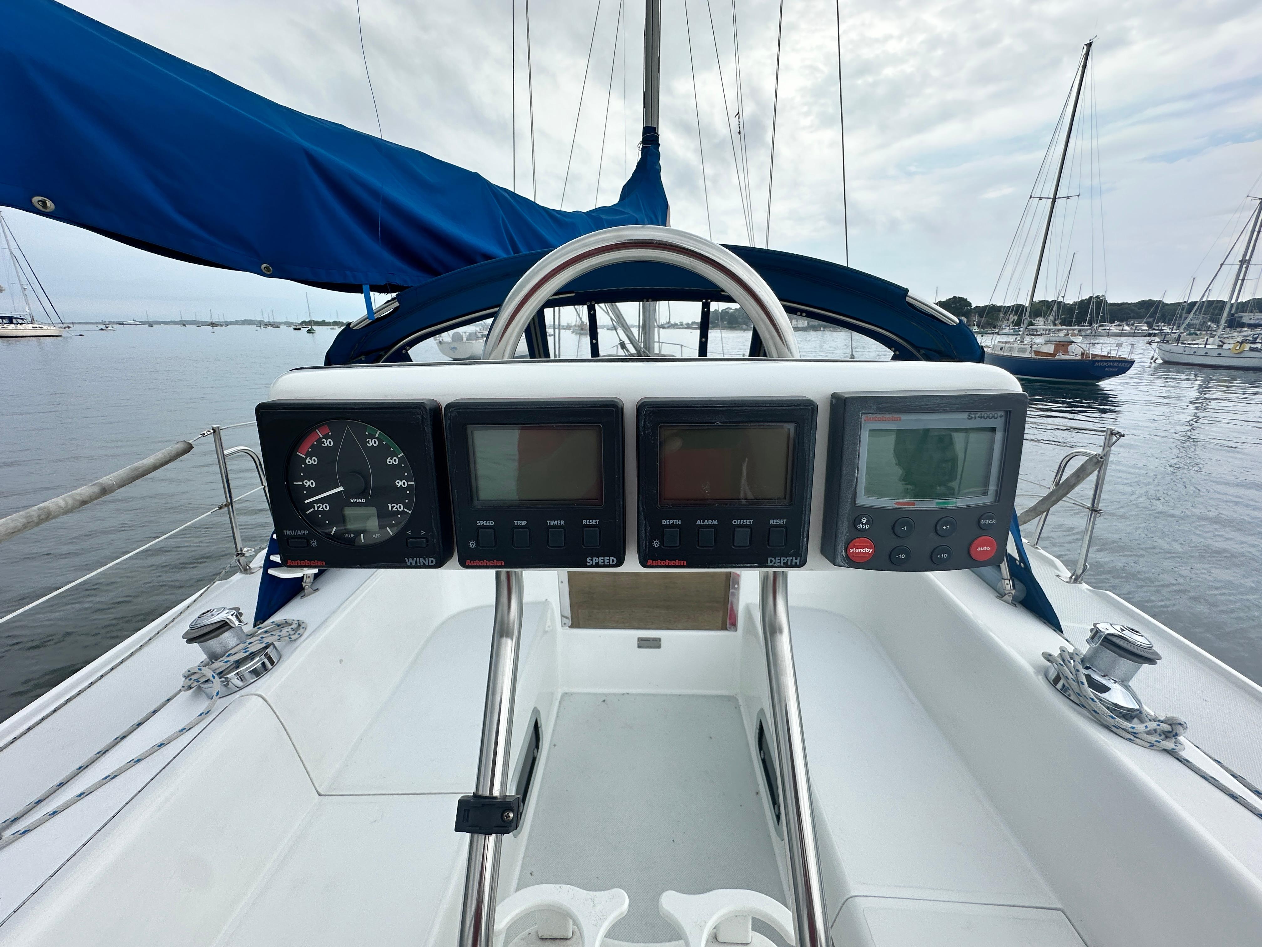 Cockpit view of 1999 Catalina 320 sailboat with navigation instruments and blue sail cover.