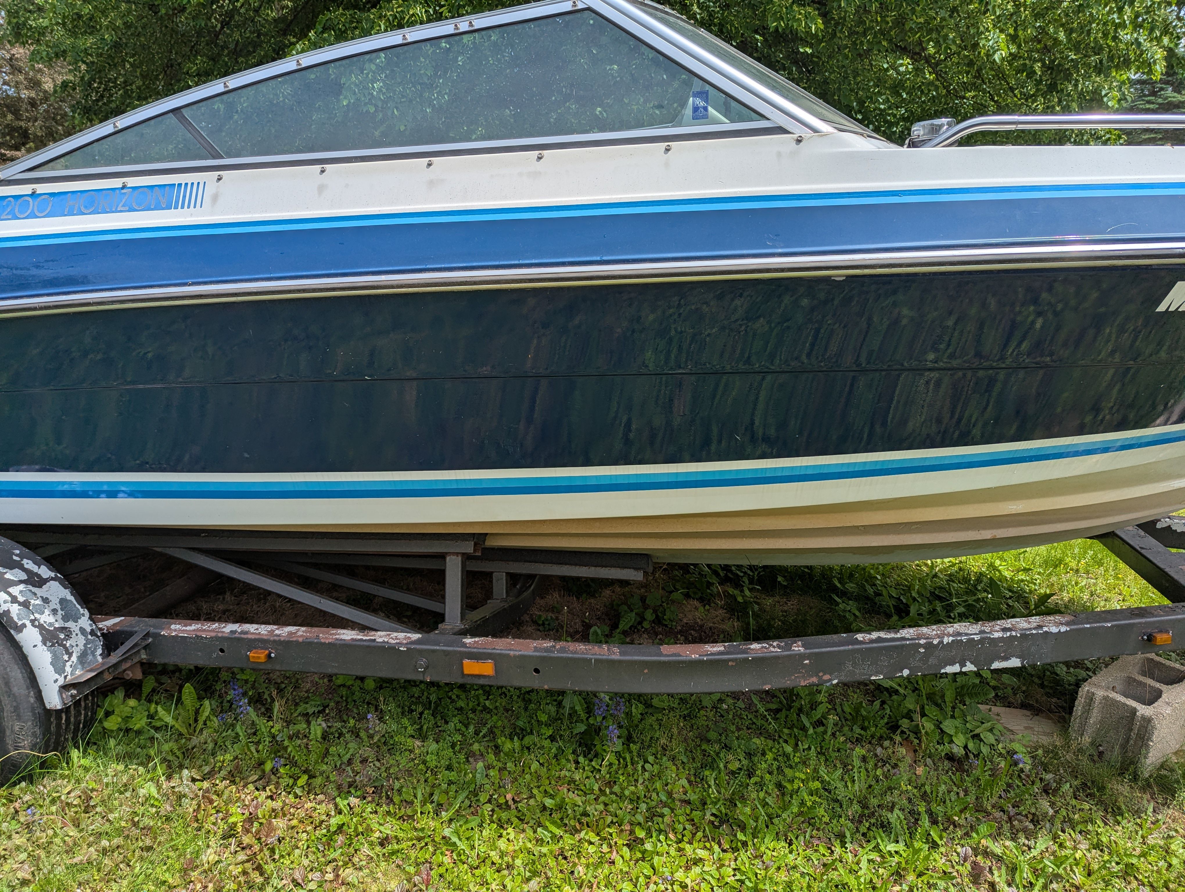 1988 Four Winns 200 Horizon boat on trailer in greenery.