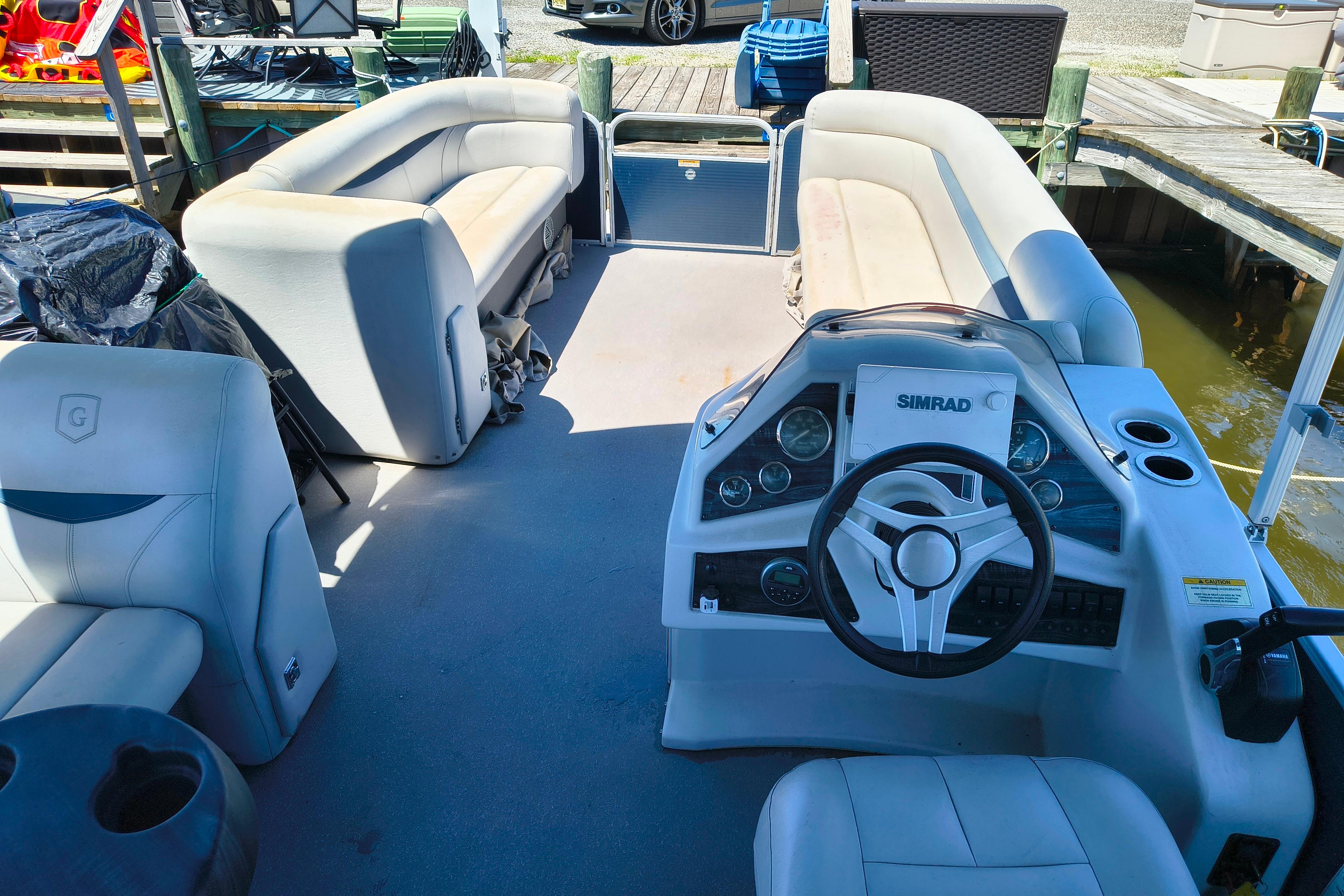 Interior of a 2018 Godfrey Sweetwater 2286 C pontoon boat with seating and steering console.