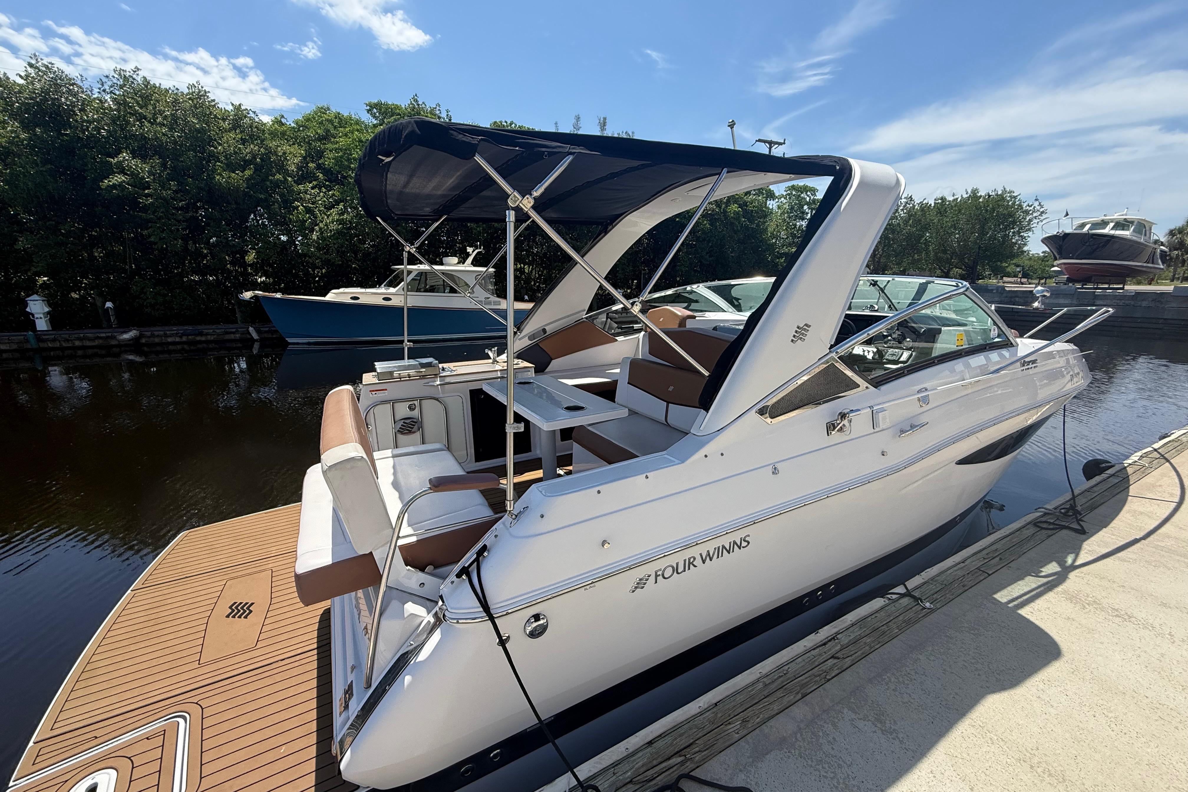2017 Four Winns V275 boat docked, featuring sleek design and spacious seating.
