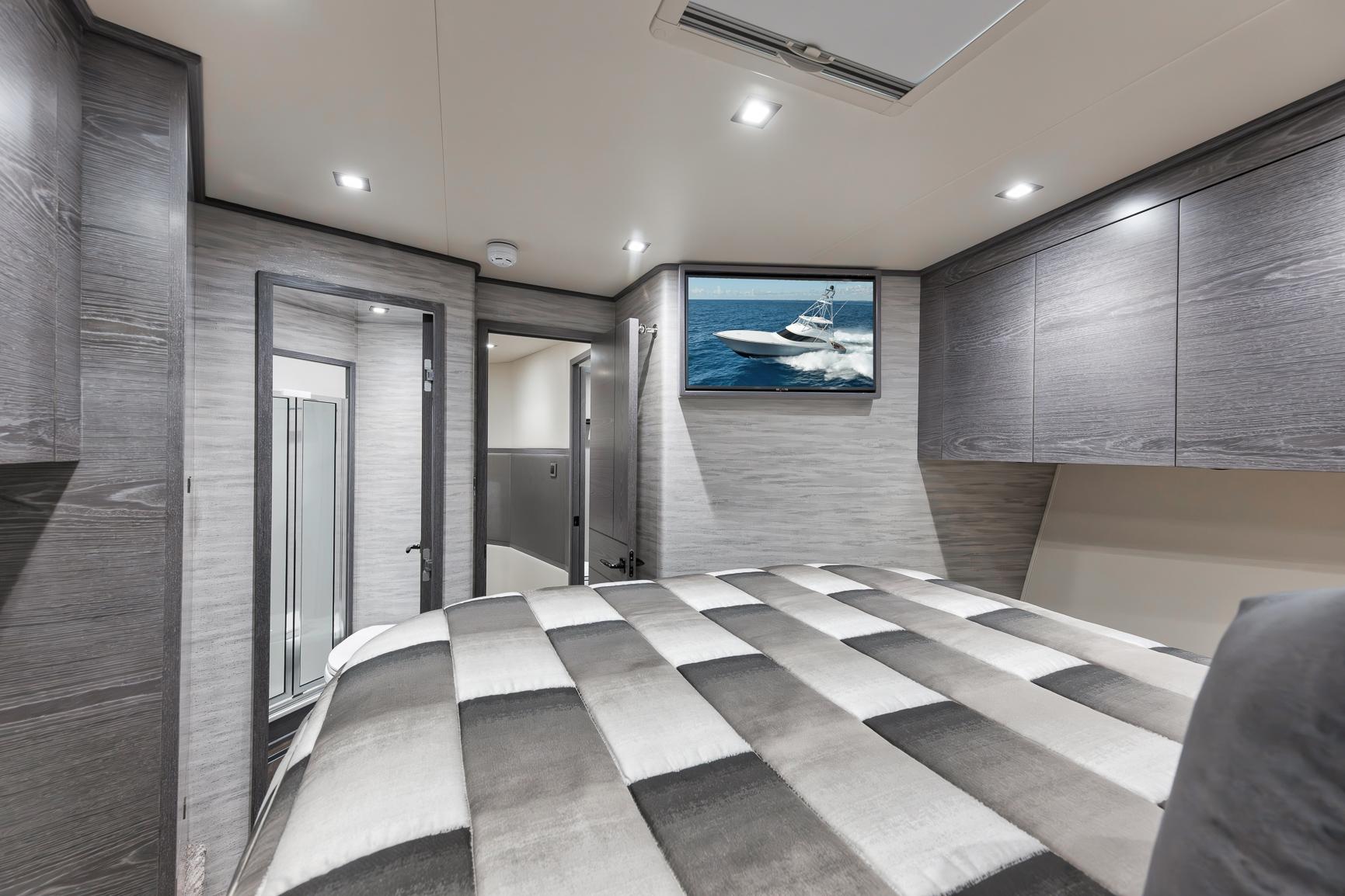 Luxurious 2024 Viking 72 Convertible yacht bedroom with modern decor and TV.
