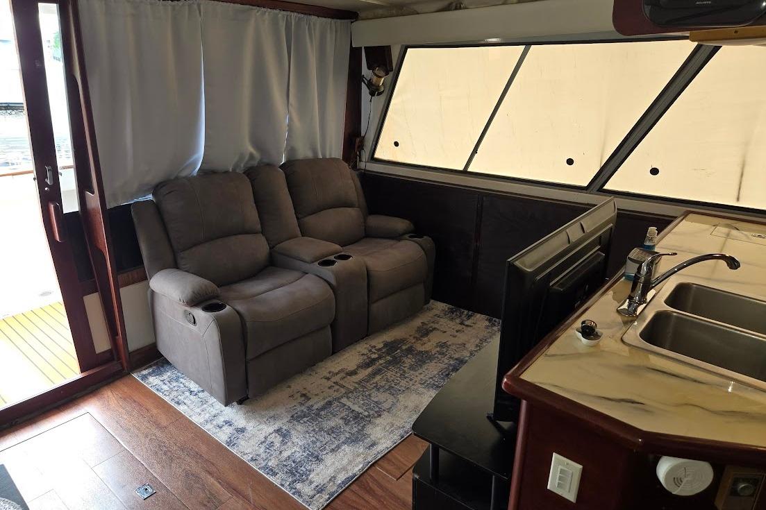Interior of 1987 Bayliner 4550 Motoryacht with recliners, TV, and kitchenette.