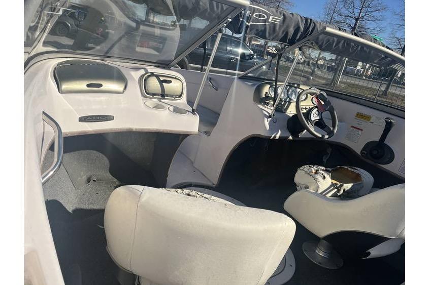 Interior of a 2006 Tahoe 206 boat with worn seats and steering wheel.